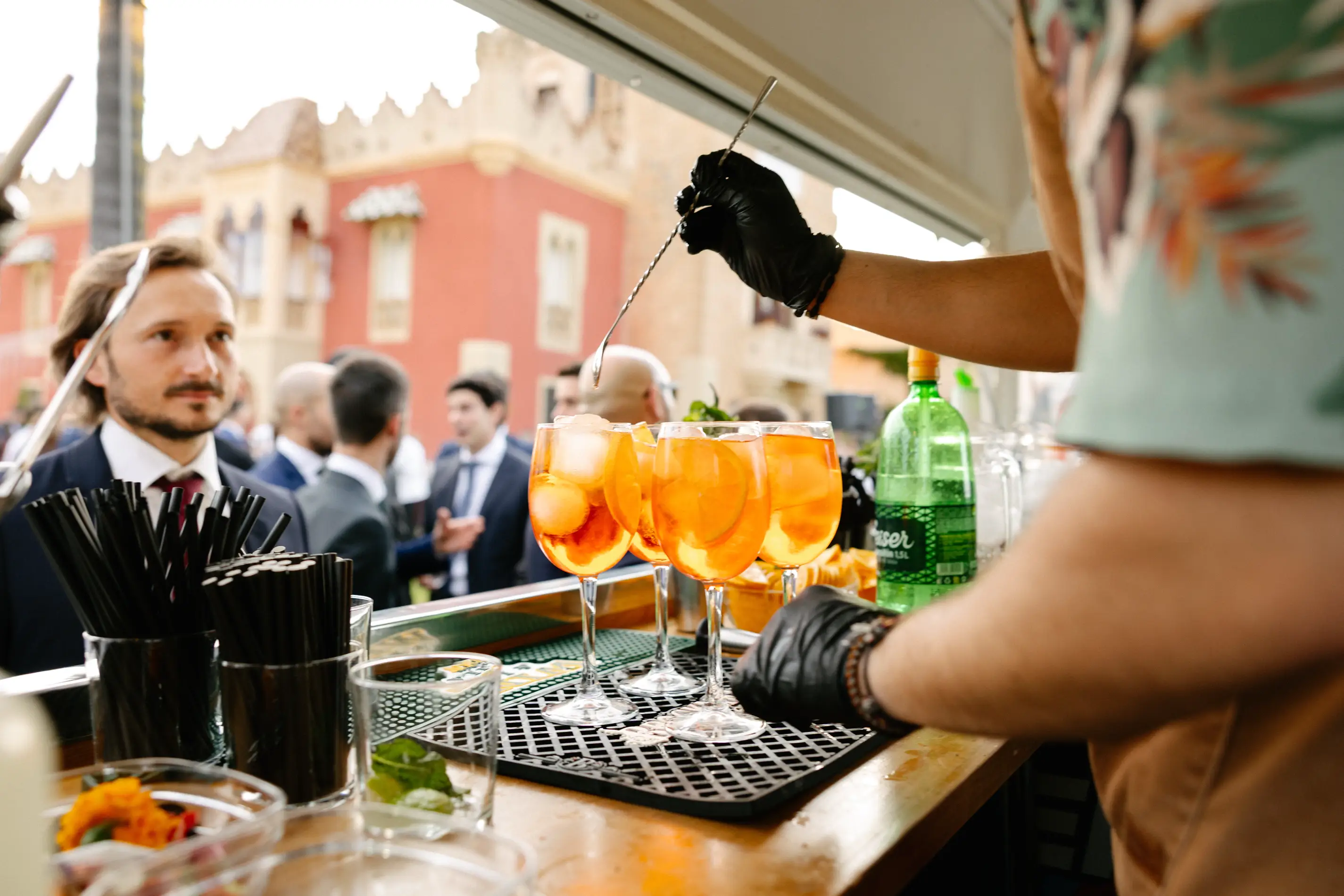 Barman prepara cócteles de color naranja en la barra exterior, en Badajoz