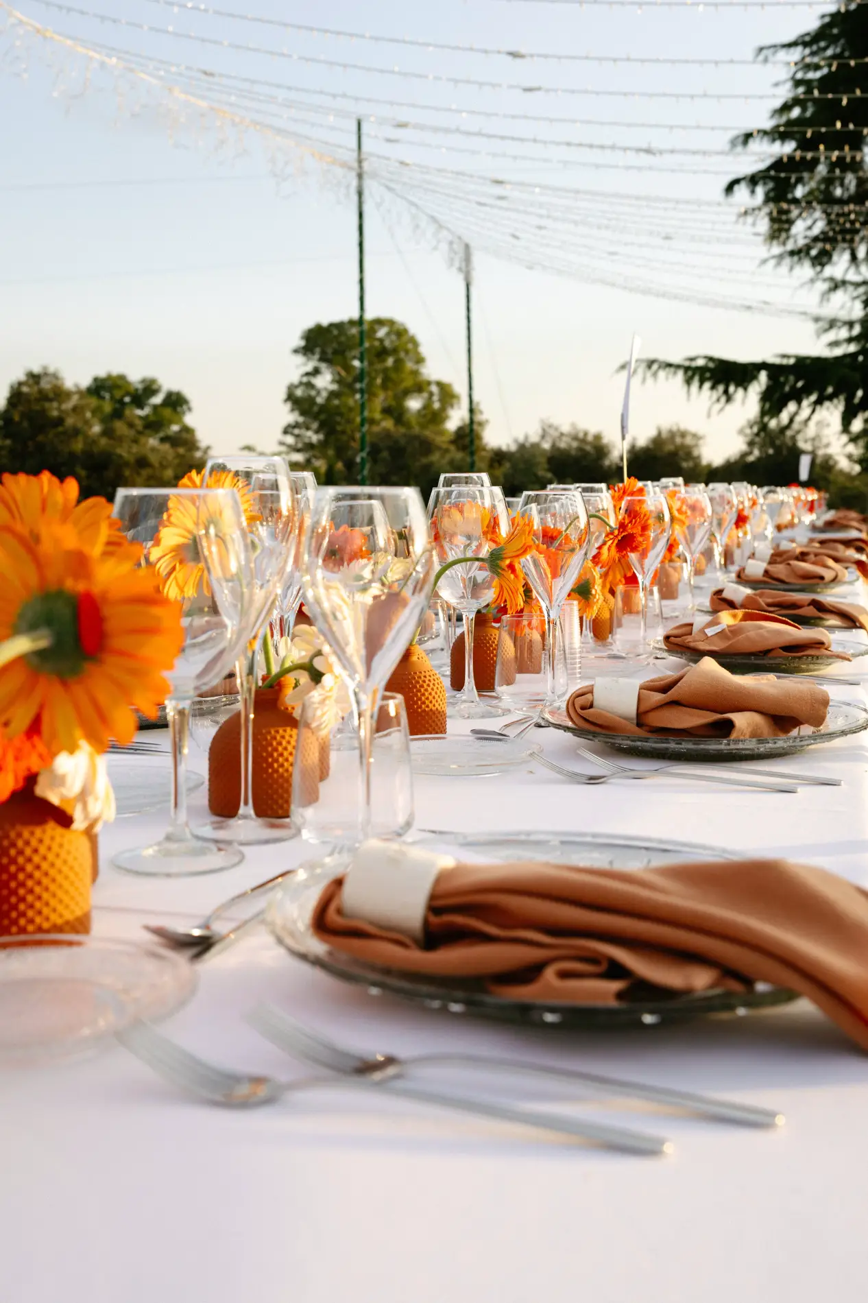 Mesa del banquete con gerberas naranjas y servilletas de lino, en Badajoz