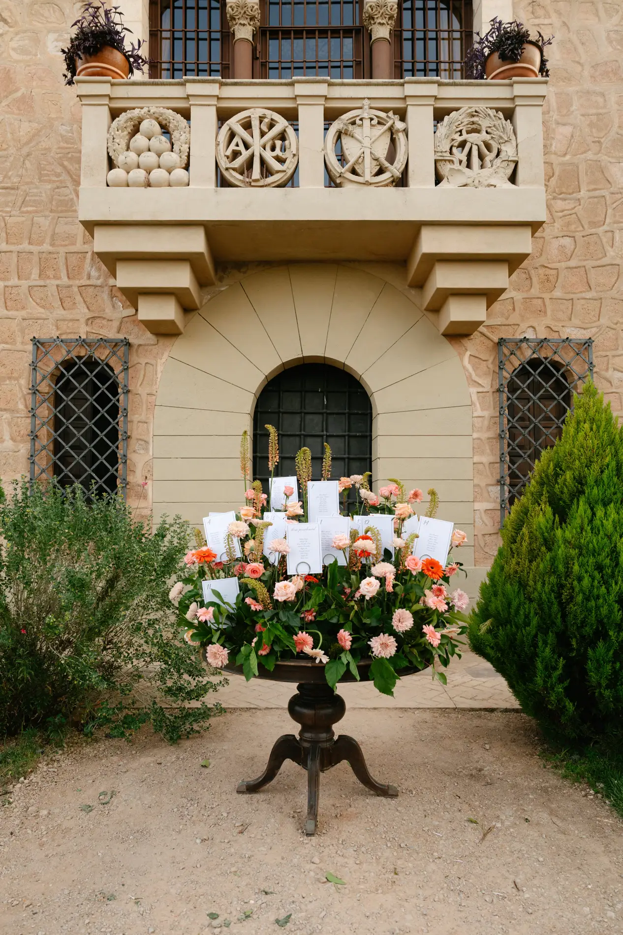 Seating plan con flores bajo el balcón de piedra de Casa Colorada