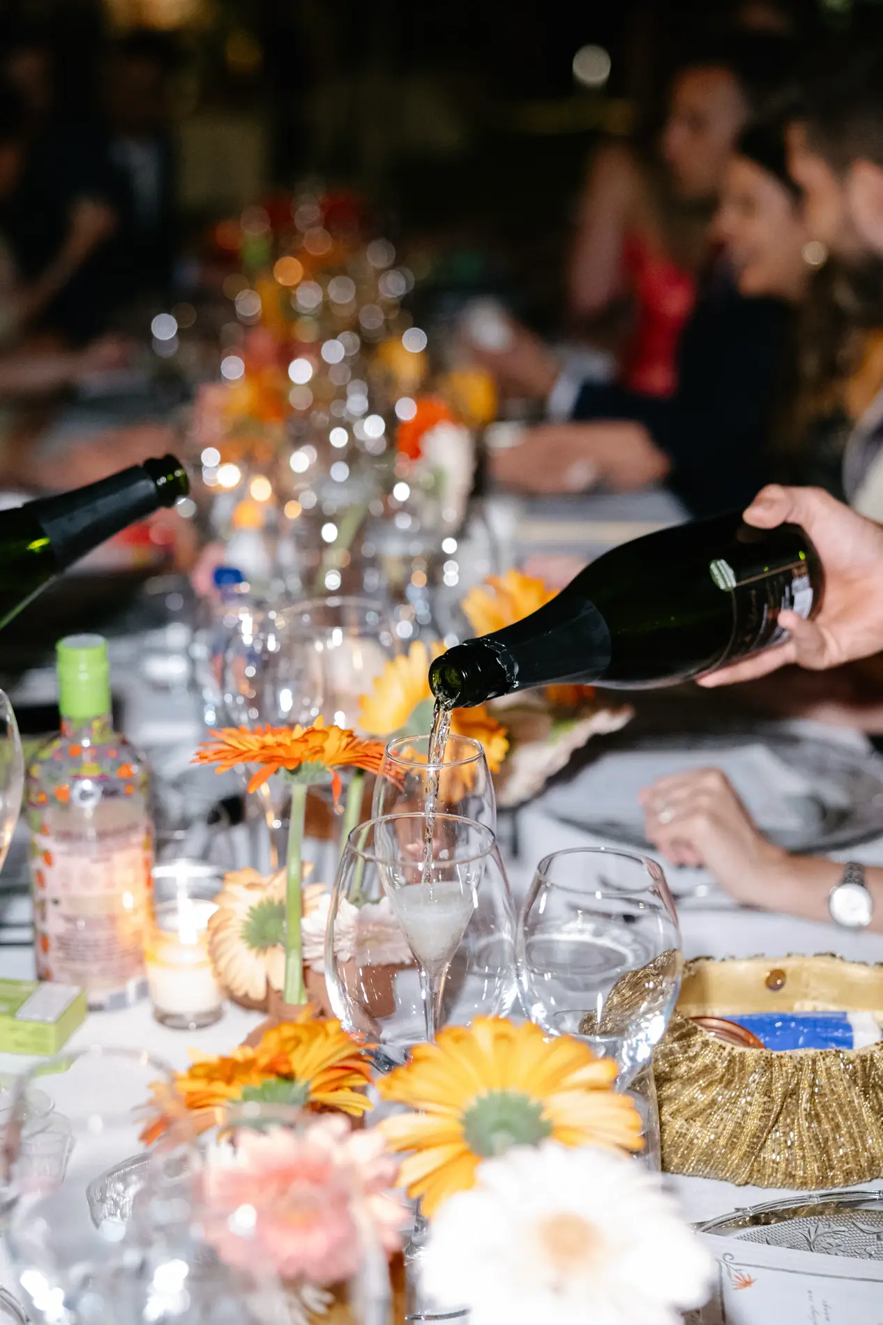 Sirven vino en la mesa del banquete decorada con gerberas, en Badajoz