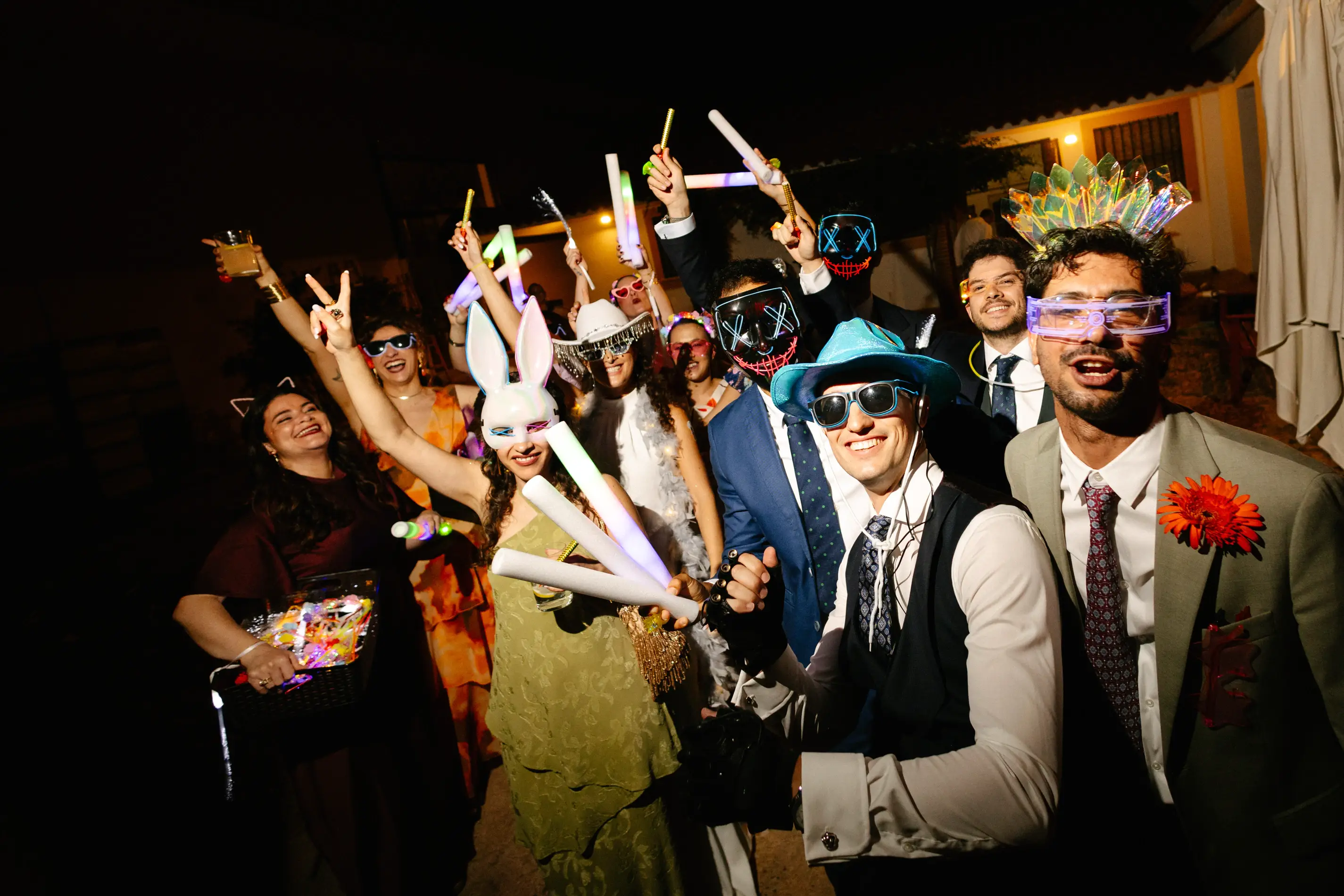 Invitados con caretas, gafas y barras de luz en la fiesta, en Badajoz