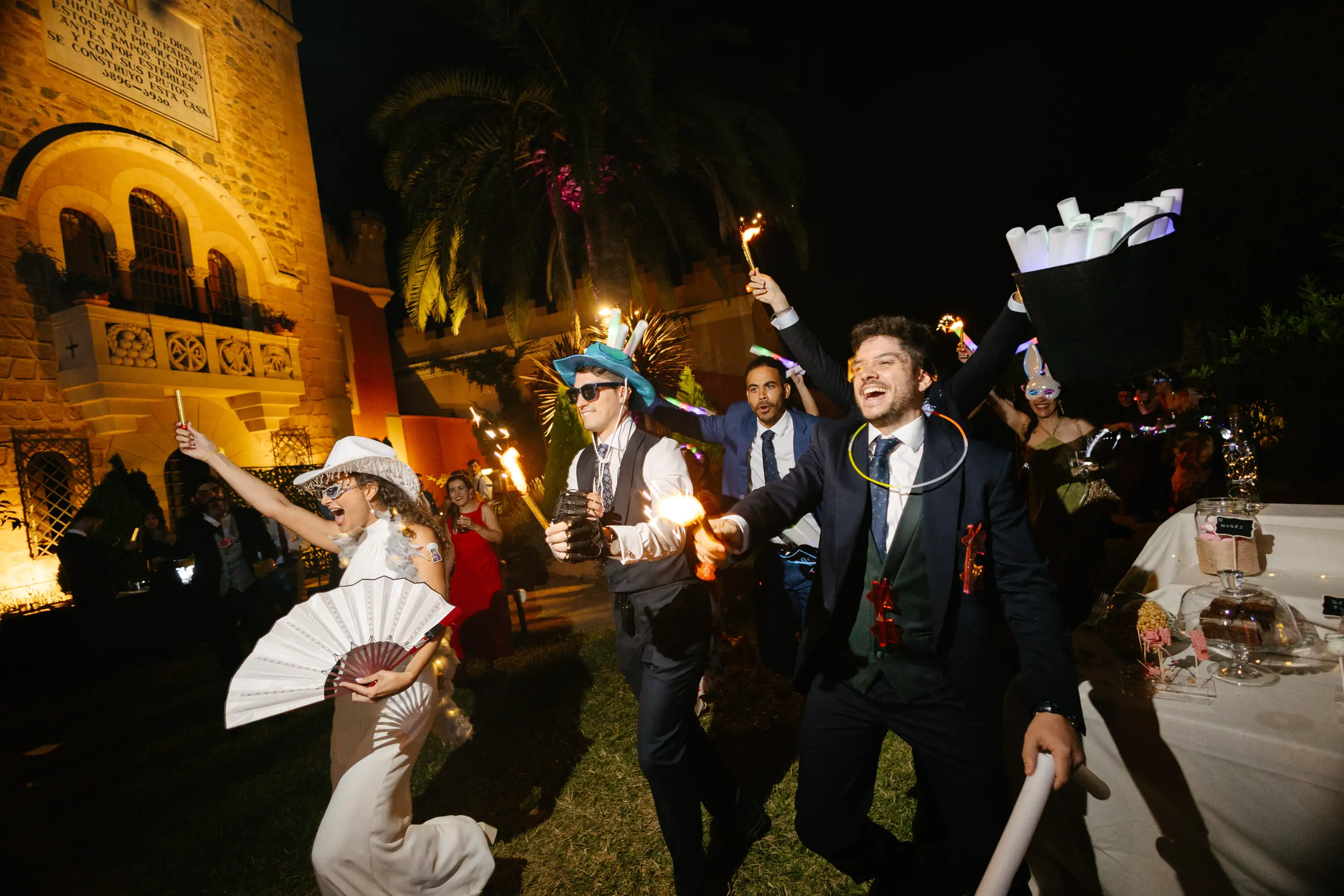 Los invitados bailan con abanicos y luces junto al palacete de noche, en Badajoz