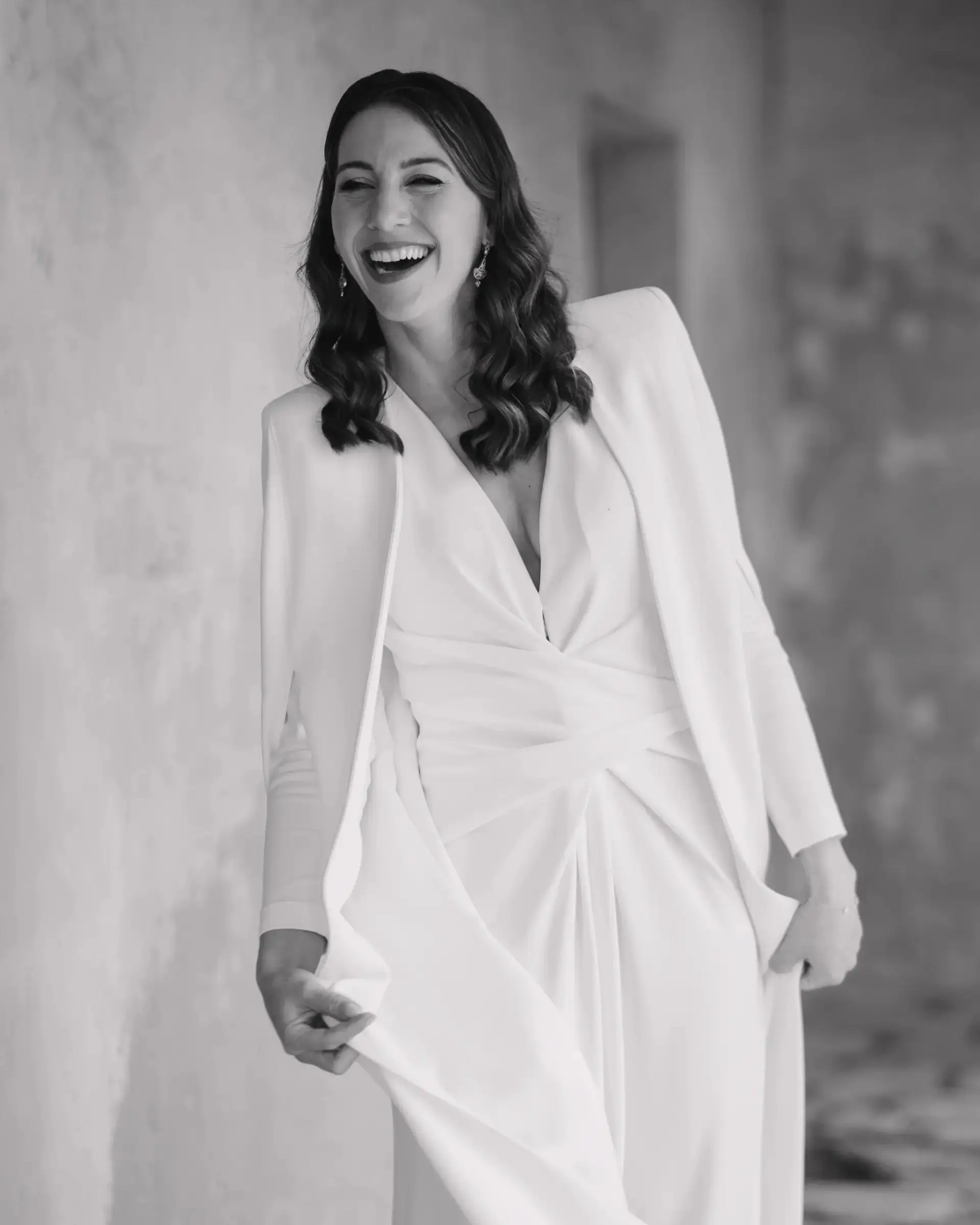 Novia sonriente con traje blanco de chaqueta, en blanco y negro
