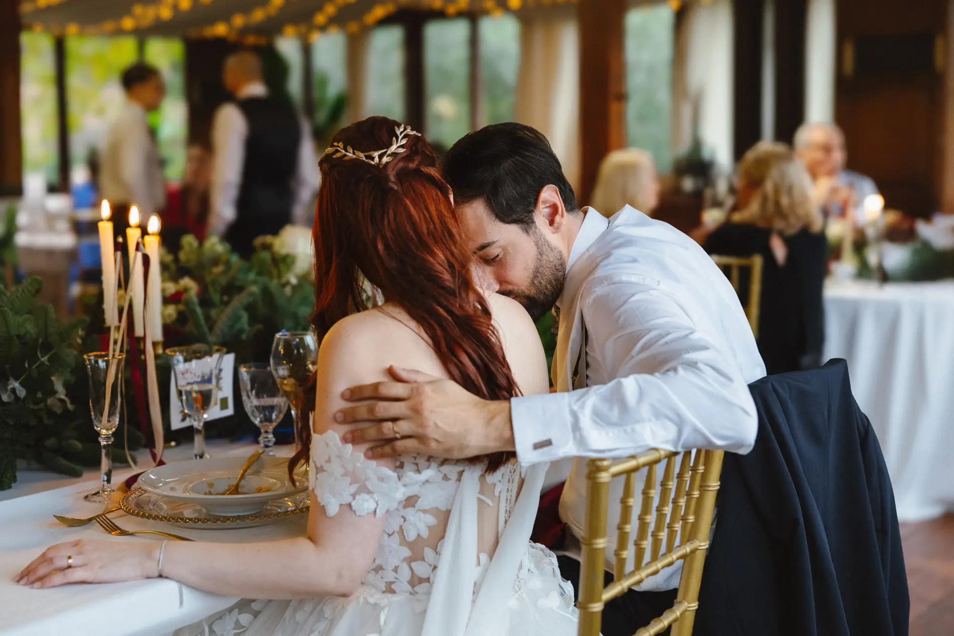 El novio abraza a la novia pelirroja en la cena