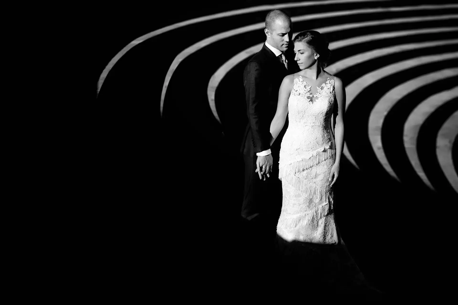 Los novios en una escalera de caracol de luz y sombra, en blanco y negro