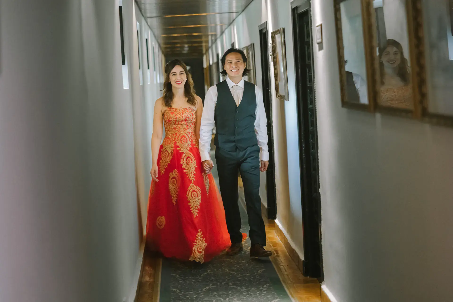 Los novios caminan por un pasillo con cuadros