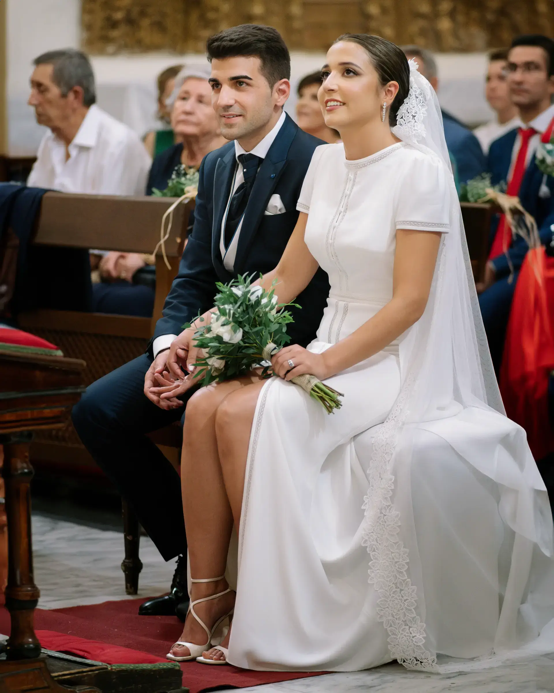 Los novios sentados en la iglesia durante la ceremonia