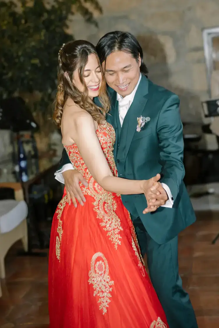 La novia, con vestido rojo bordado, baila con el novio
