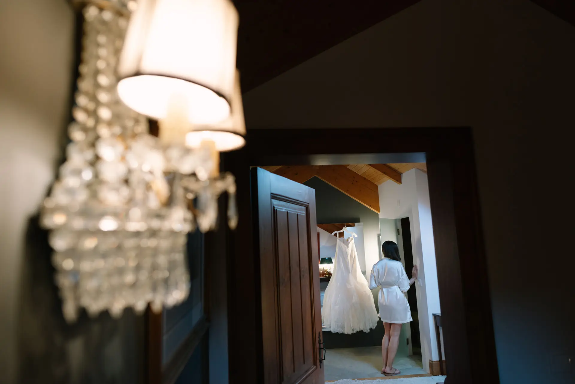 Vestido de novia colgado al fondo de un pasillo con aplique de cristal, en la Quinta da Grila, Lisboa