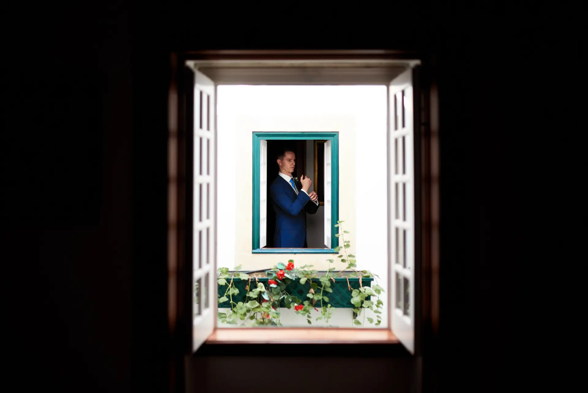 Quinn espera en una ventana con flores, en la Quinta da Grila, Lisboa