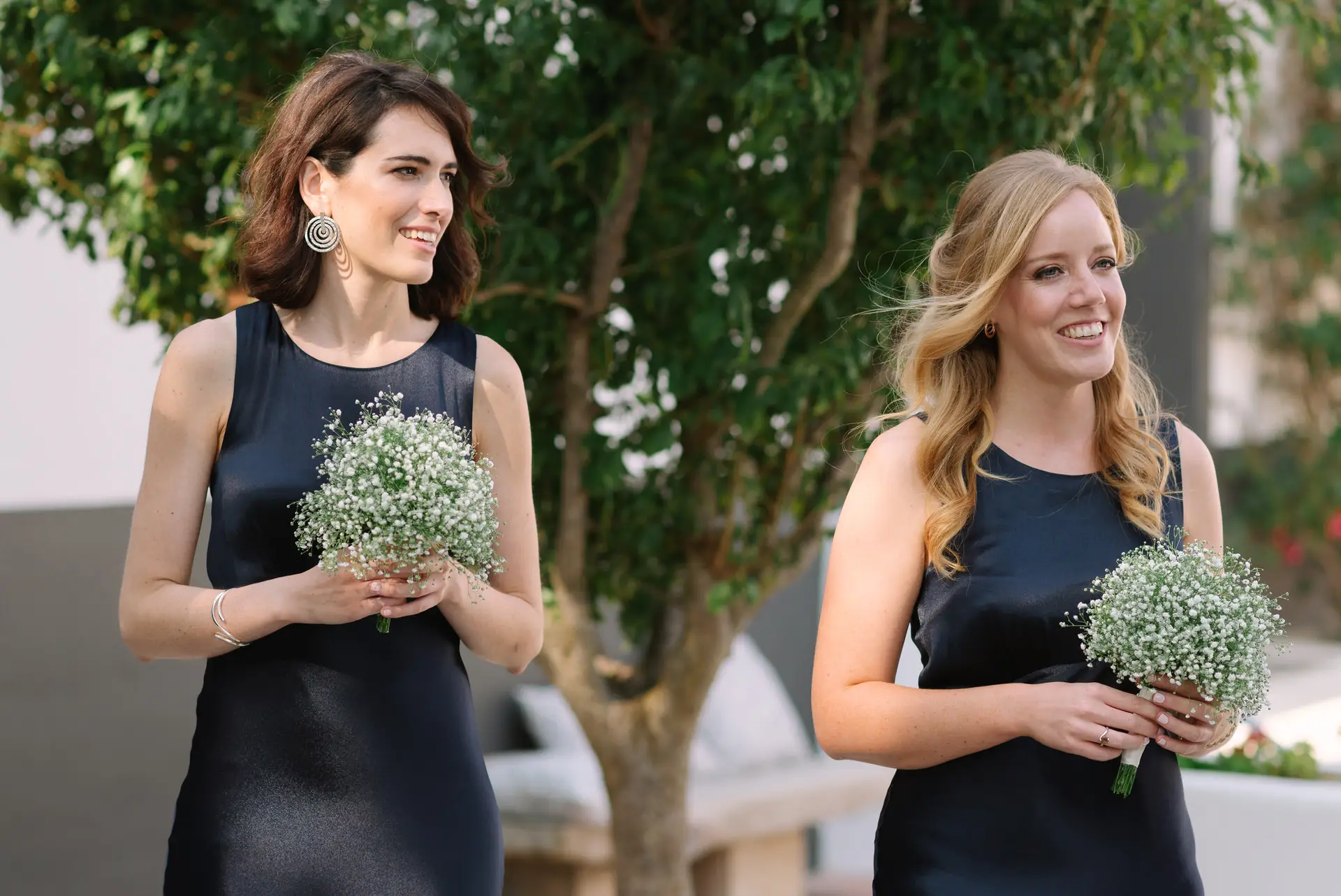 Dos damas de honor sonríen con sus ramos, en la Quinta da Grila, Lisboa