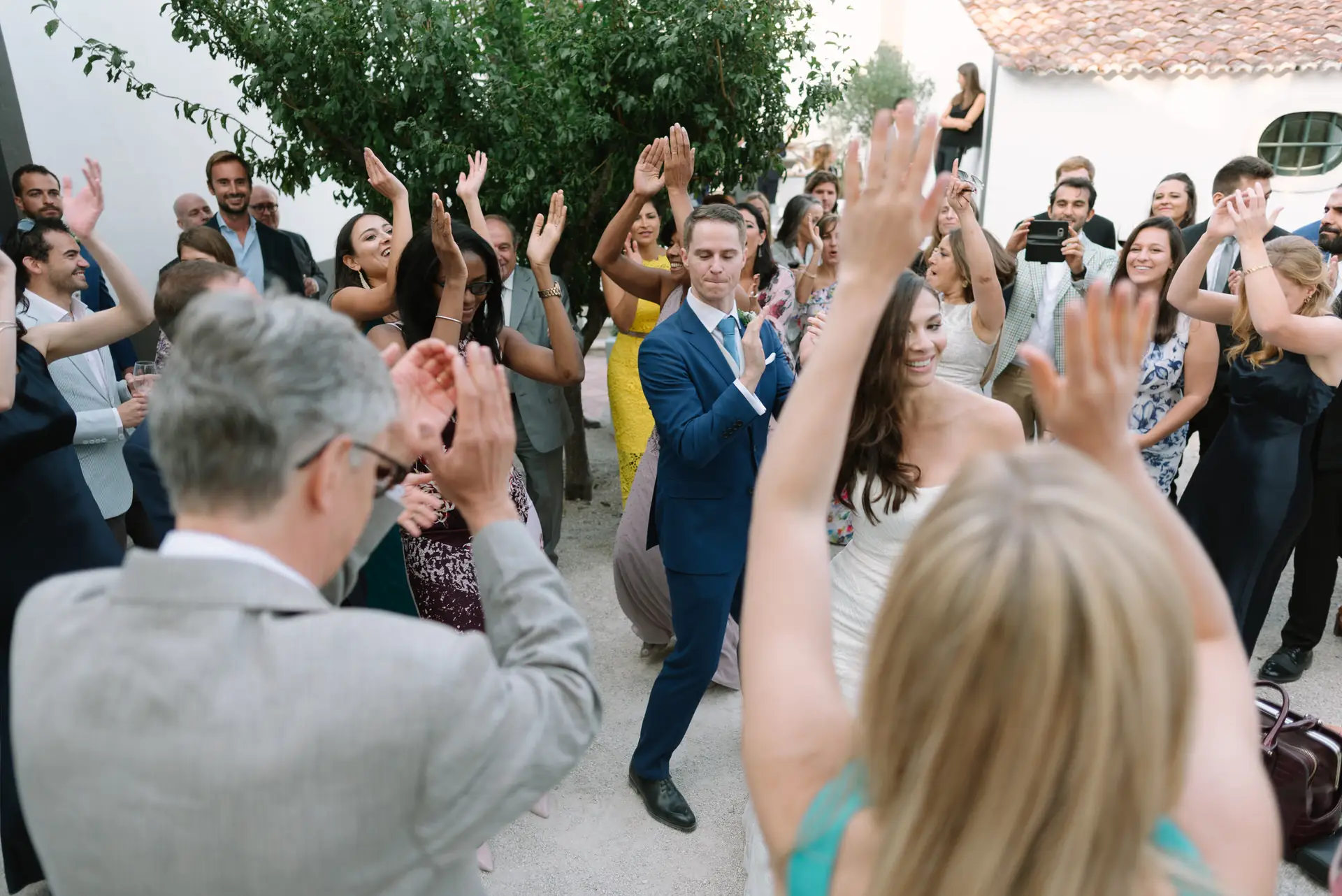 Invitados aplauden y bailan con Alana y Quinn en el patio, en la Quinta da Grila, Lisboa