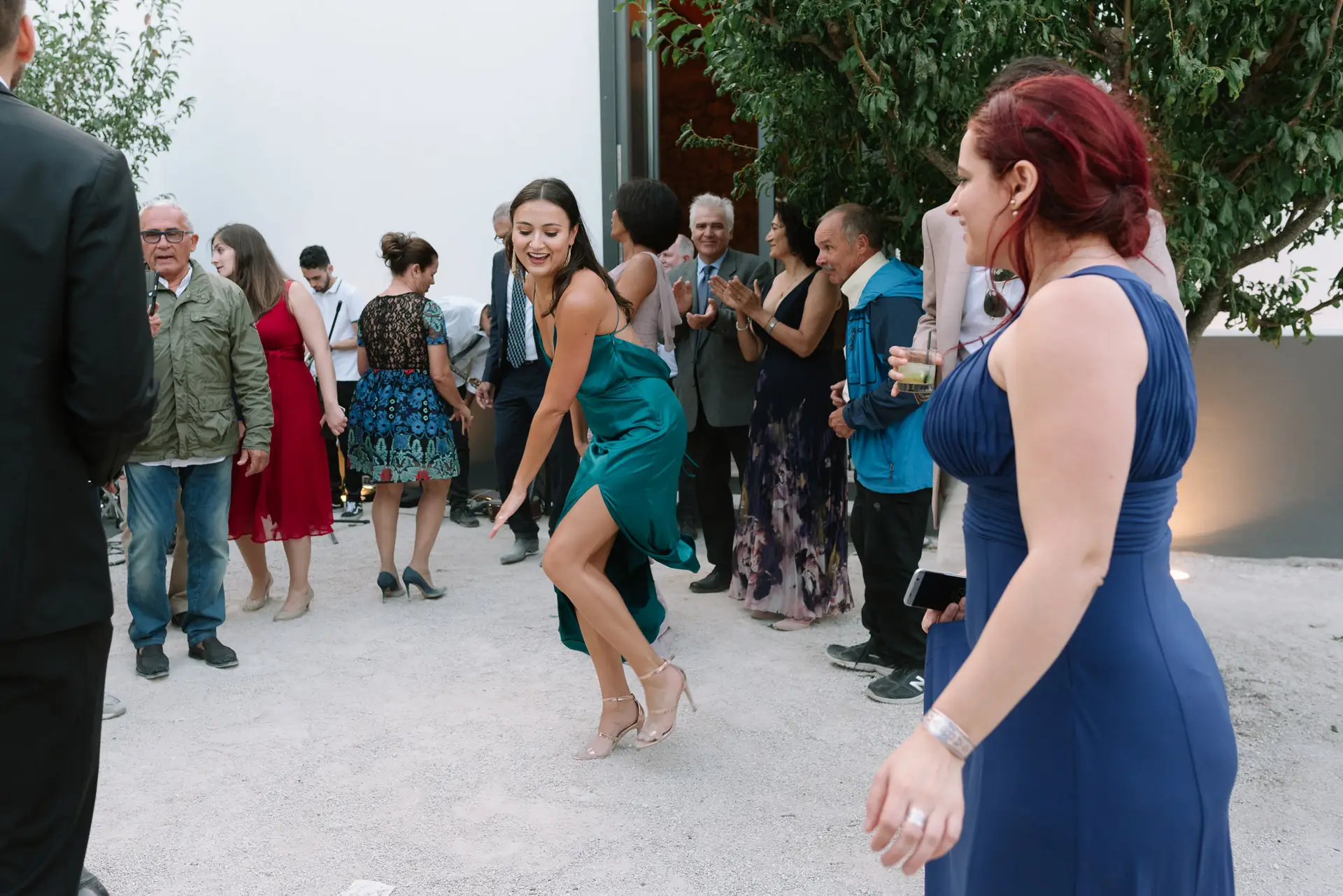 Invitados bailan en corro en el patio de la quinta