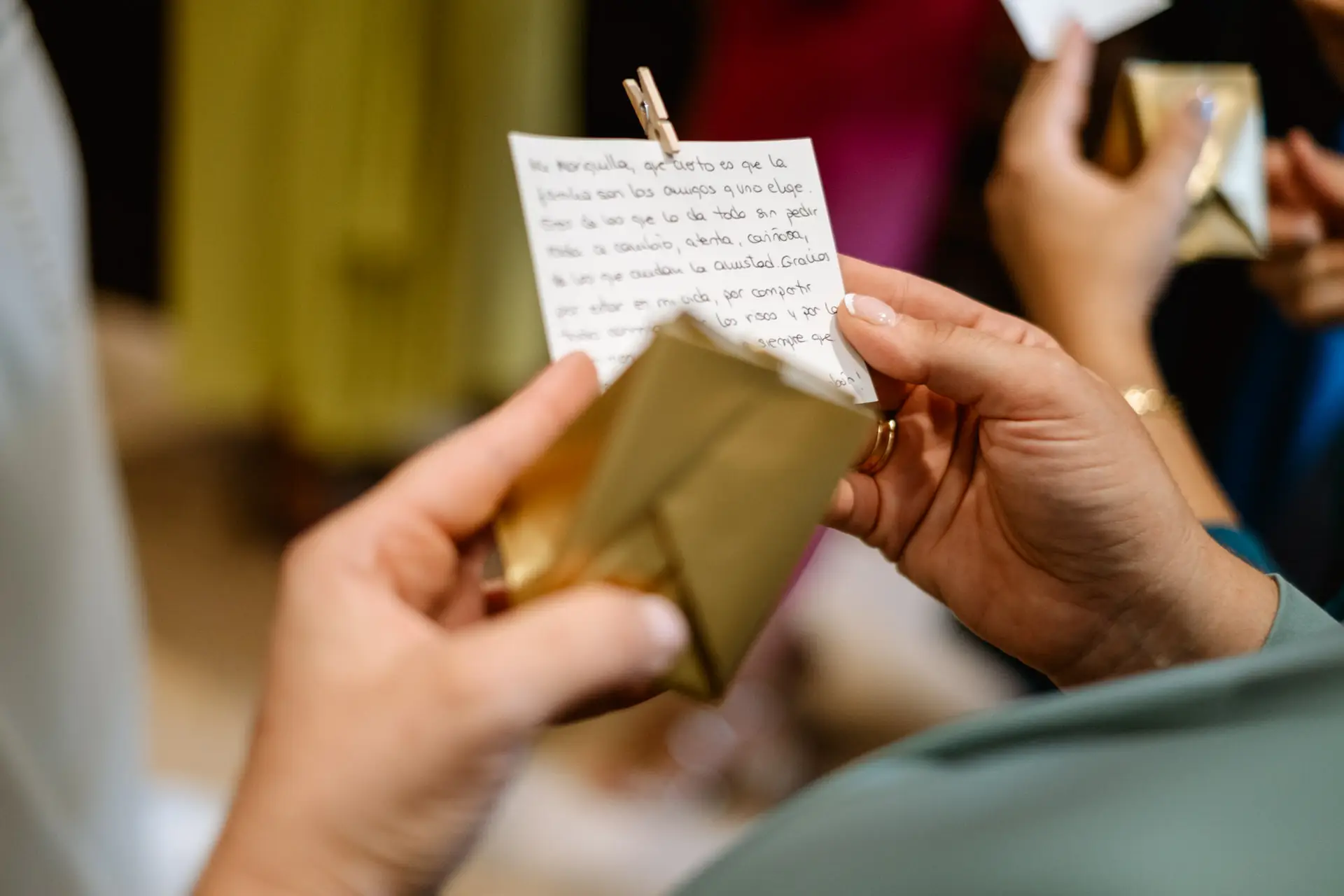 Unas manos abren una carta con un sobre dorado, en Jerez de los Caballeros