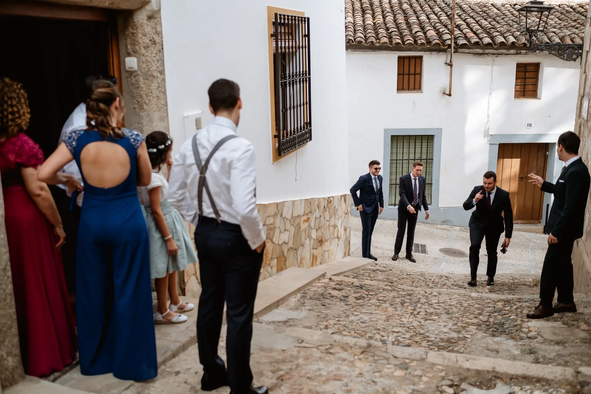 Invitados en una calle de casas blancas, camino de la boda, en Jerez de los Caballeros