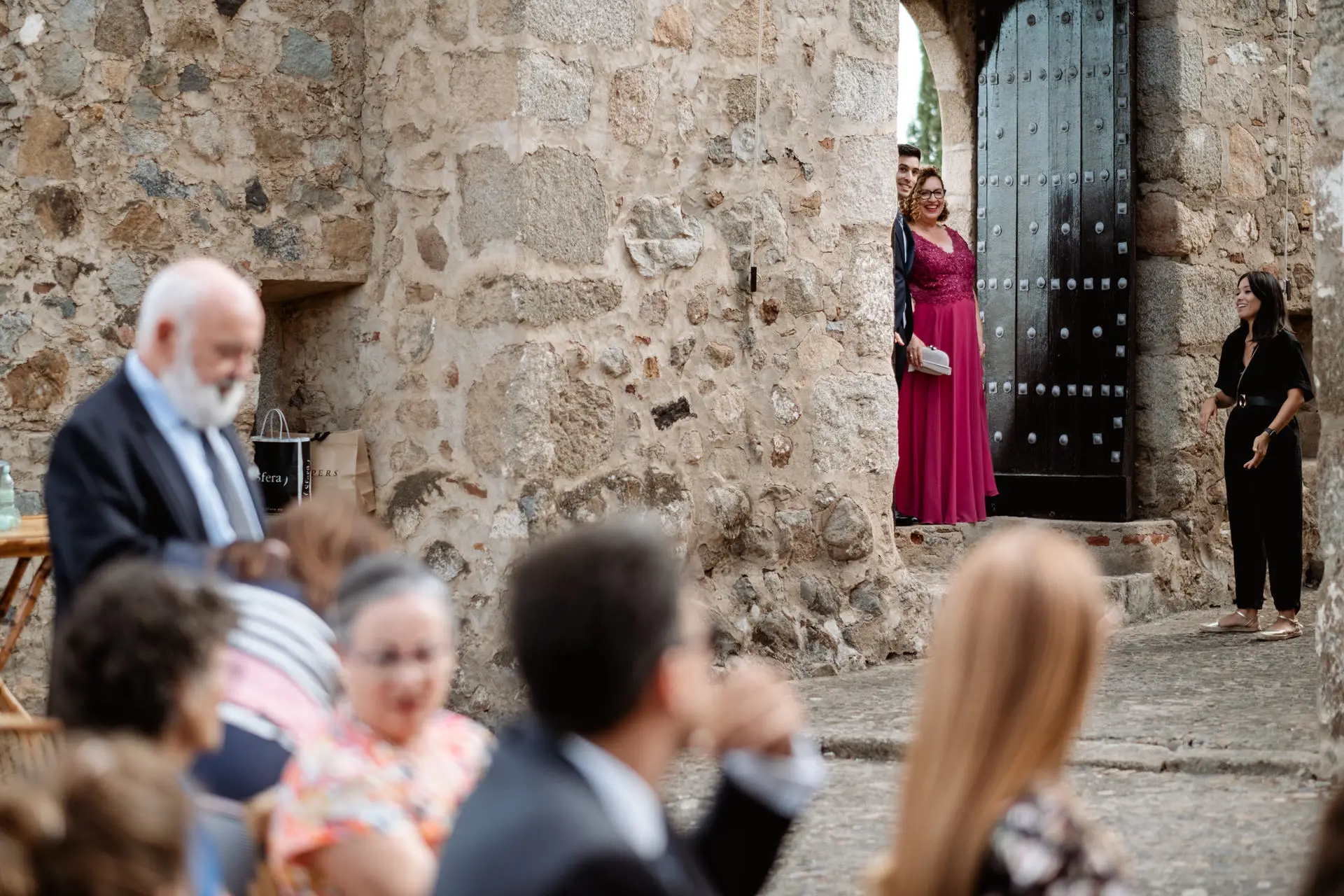 Invitados junto a la puerta de piedra del castillo