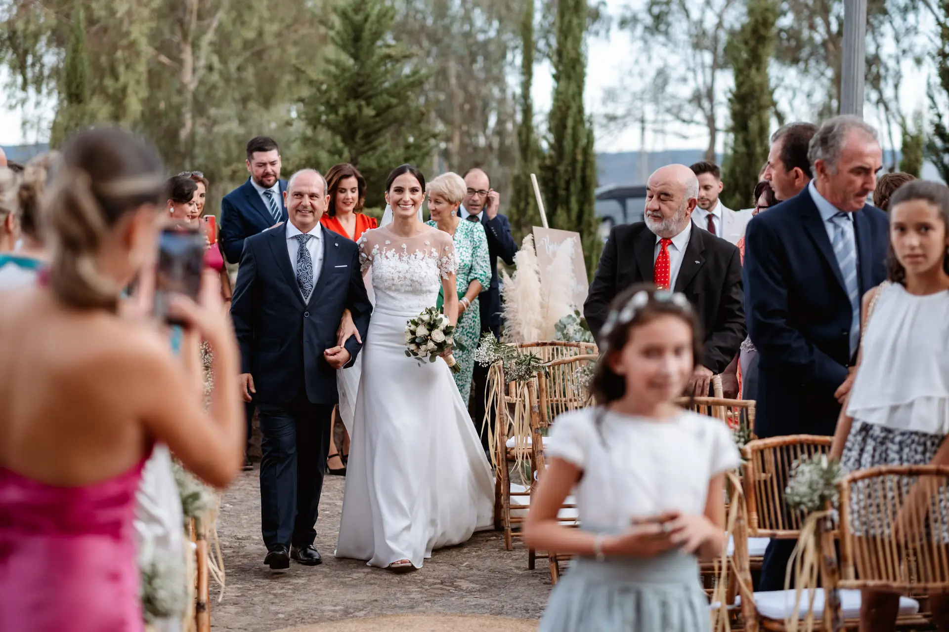 Rocío entra del brazo de su padre entre los invitados, en Jerez de los Caballeros