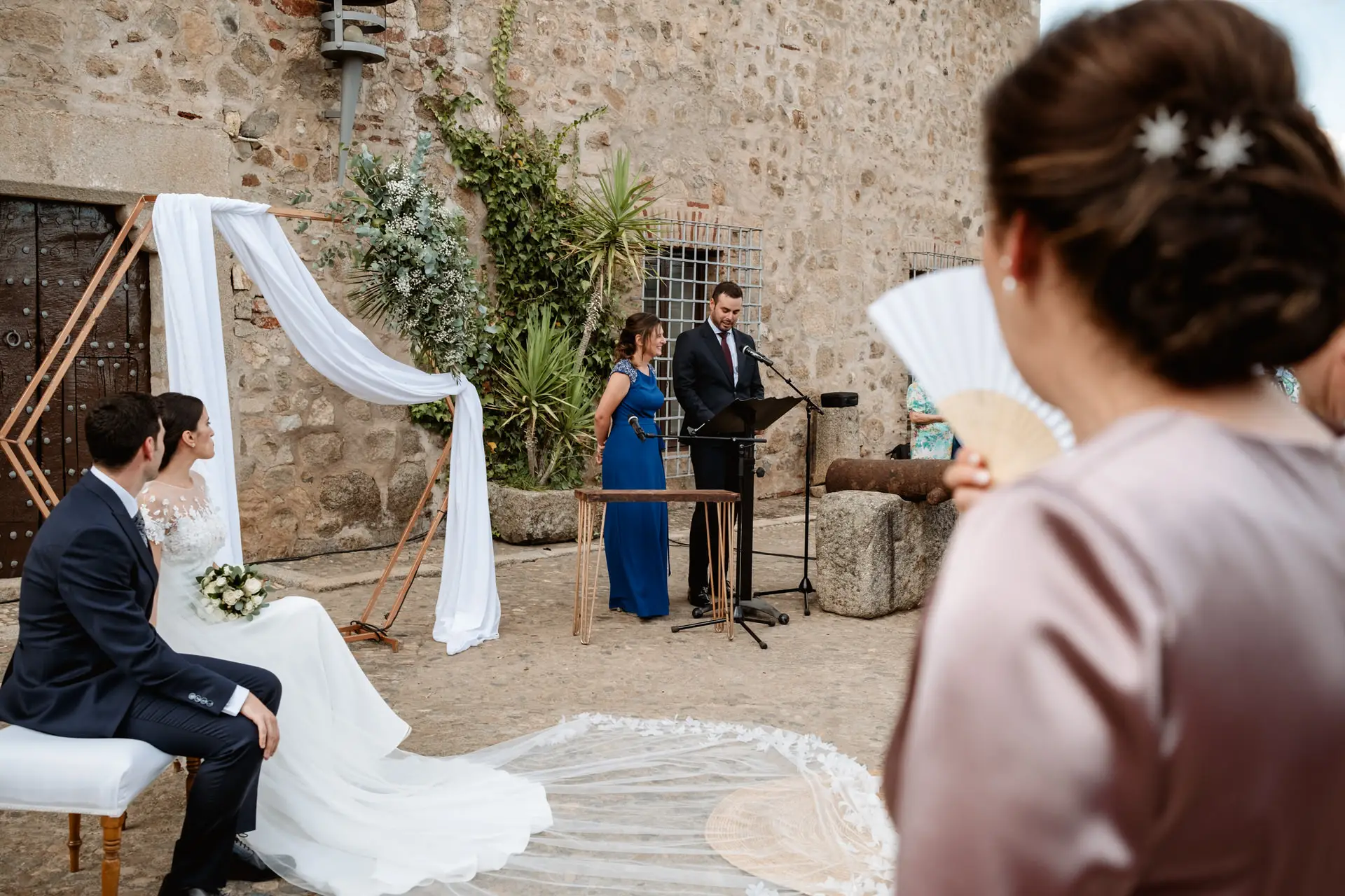 Una invitada lee durante la ceremonia civil en el patio del castillo