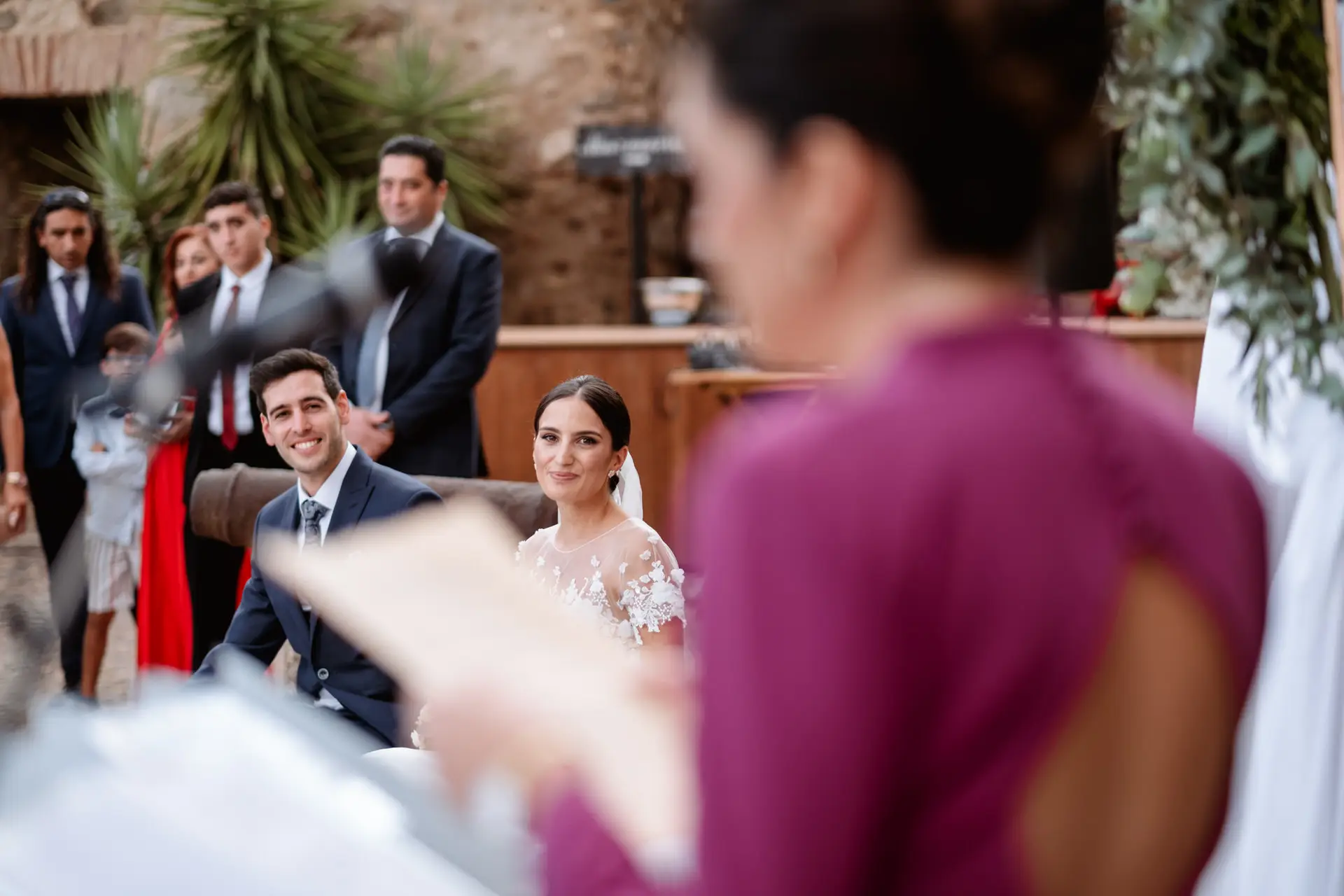 Rocío y Alberto sonríen mientras una invitada lee unas palabras, en Jerez de los Caballeros