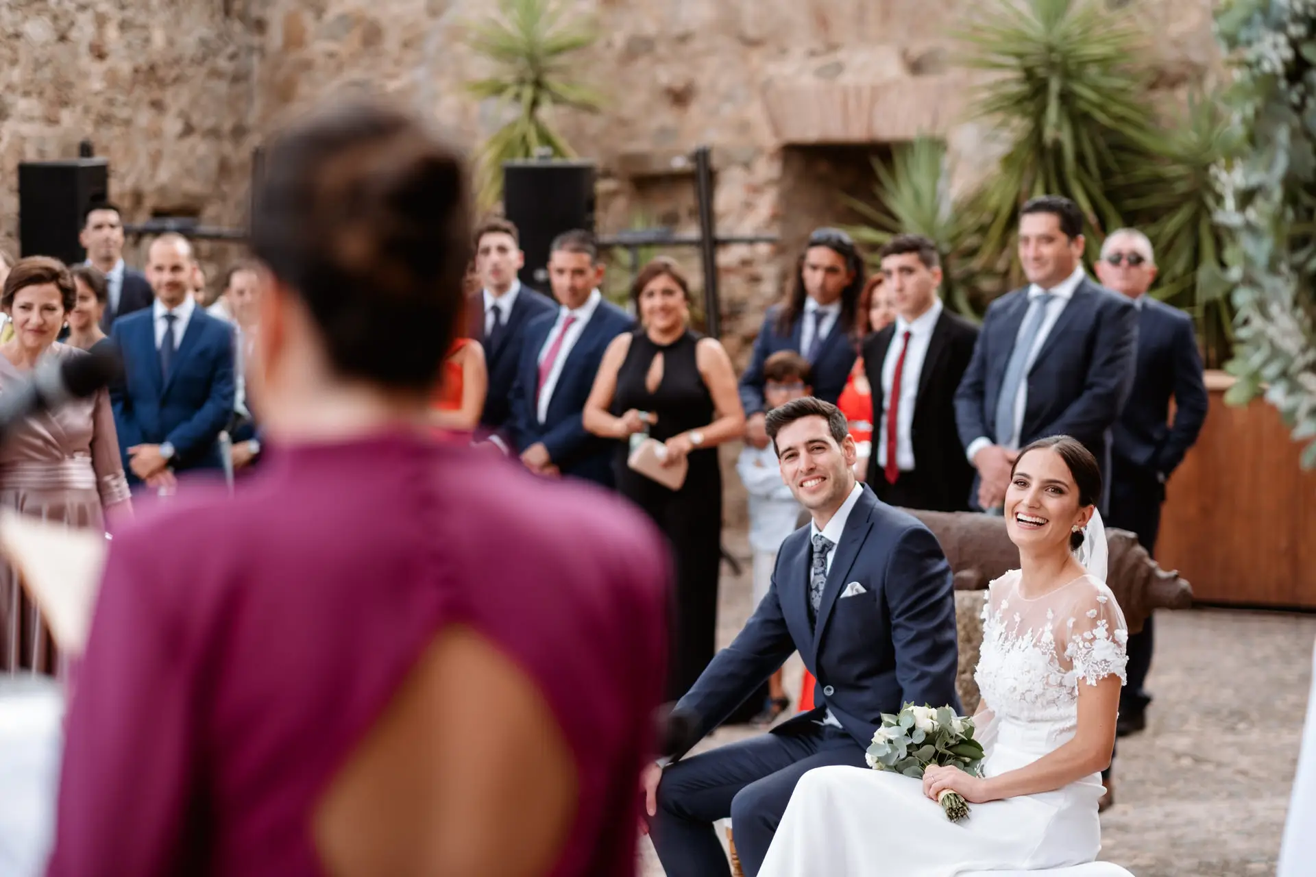 Una invitada vestida de granate lee para los novios, en Jerez de los Caballeros