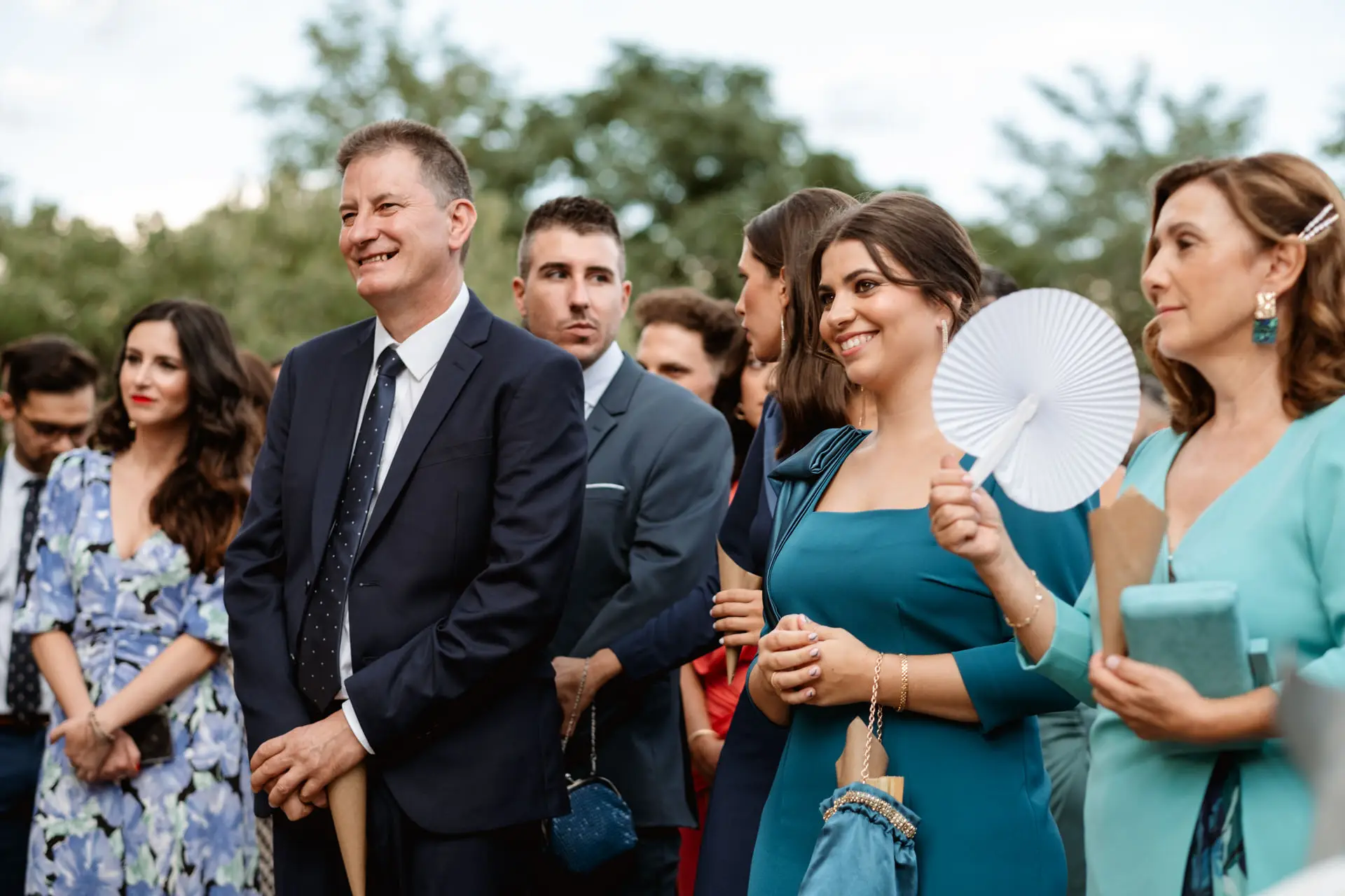 Los invitados se ríen durante la ceremonia, una de ellas con un abanico, en Jerez de los Caballeros