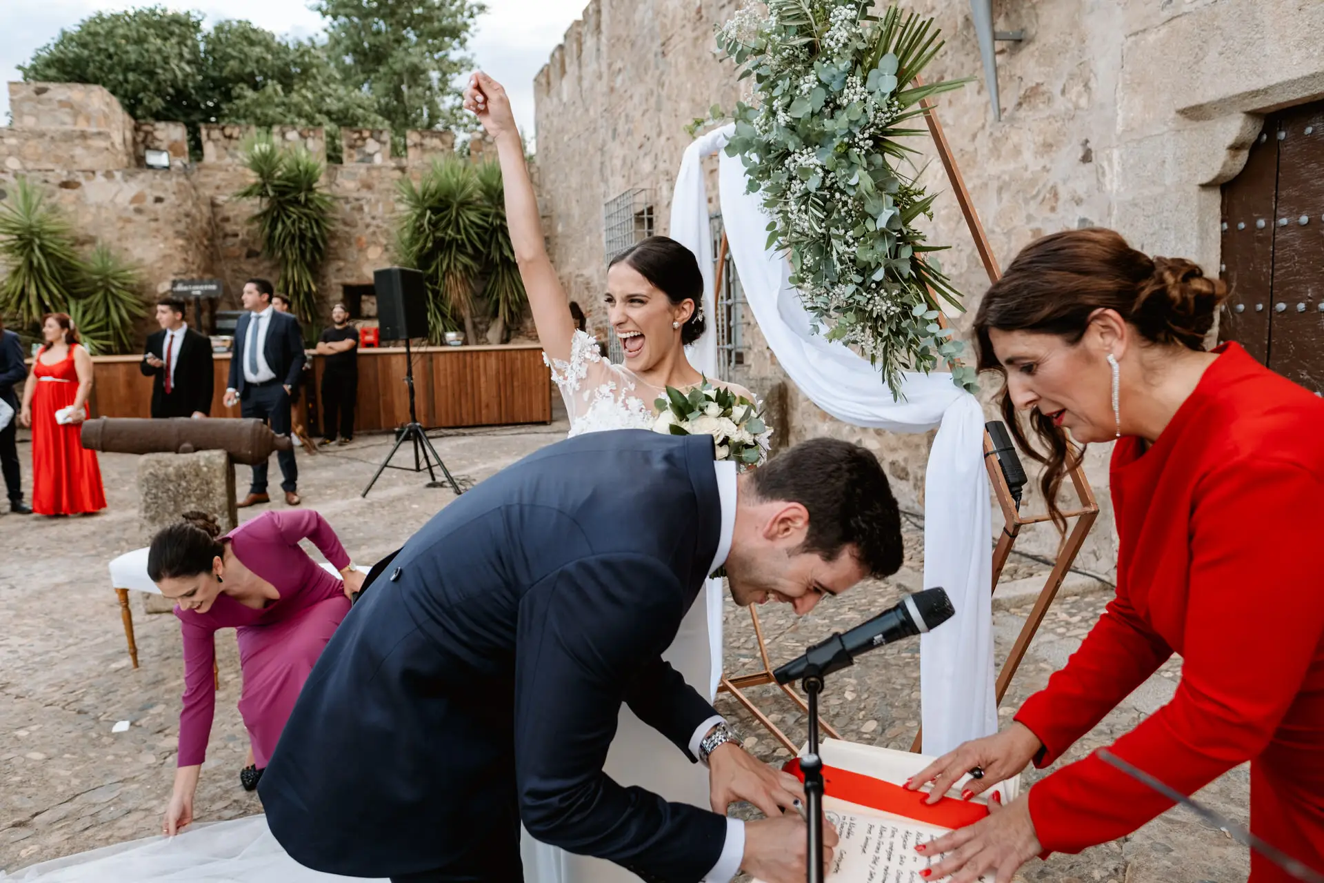 Alberto se agacha entre risas junto a una invitada vestida de rojo, en Jerez de los Caballeros