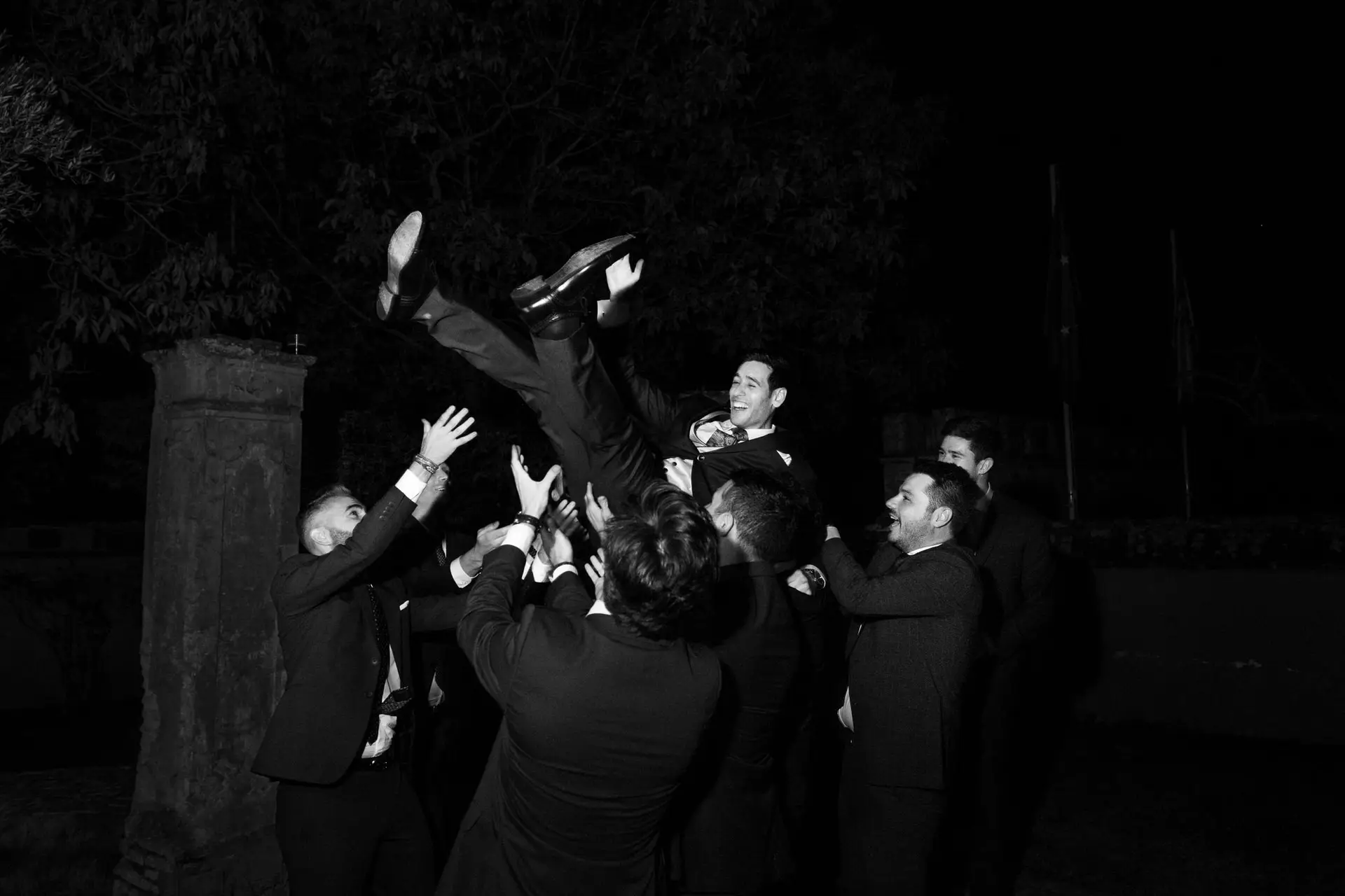 Los amigos lanzan a Alberto por los aires, en blanco y negro