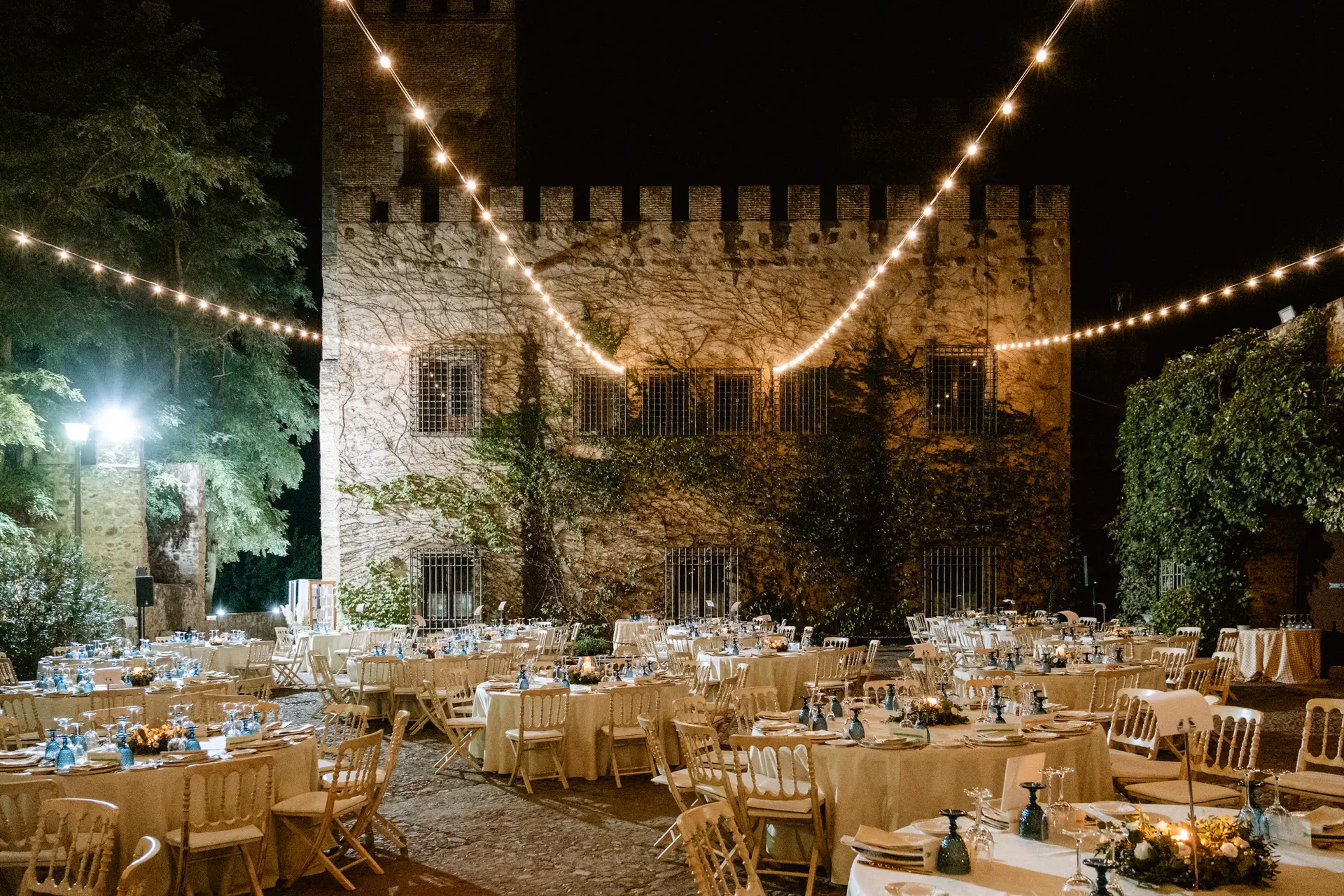 Las mesas de la cena en el patio del Castillo del Toriñuelo, iluminado de noche