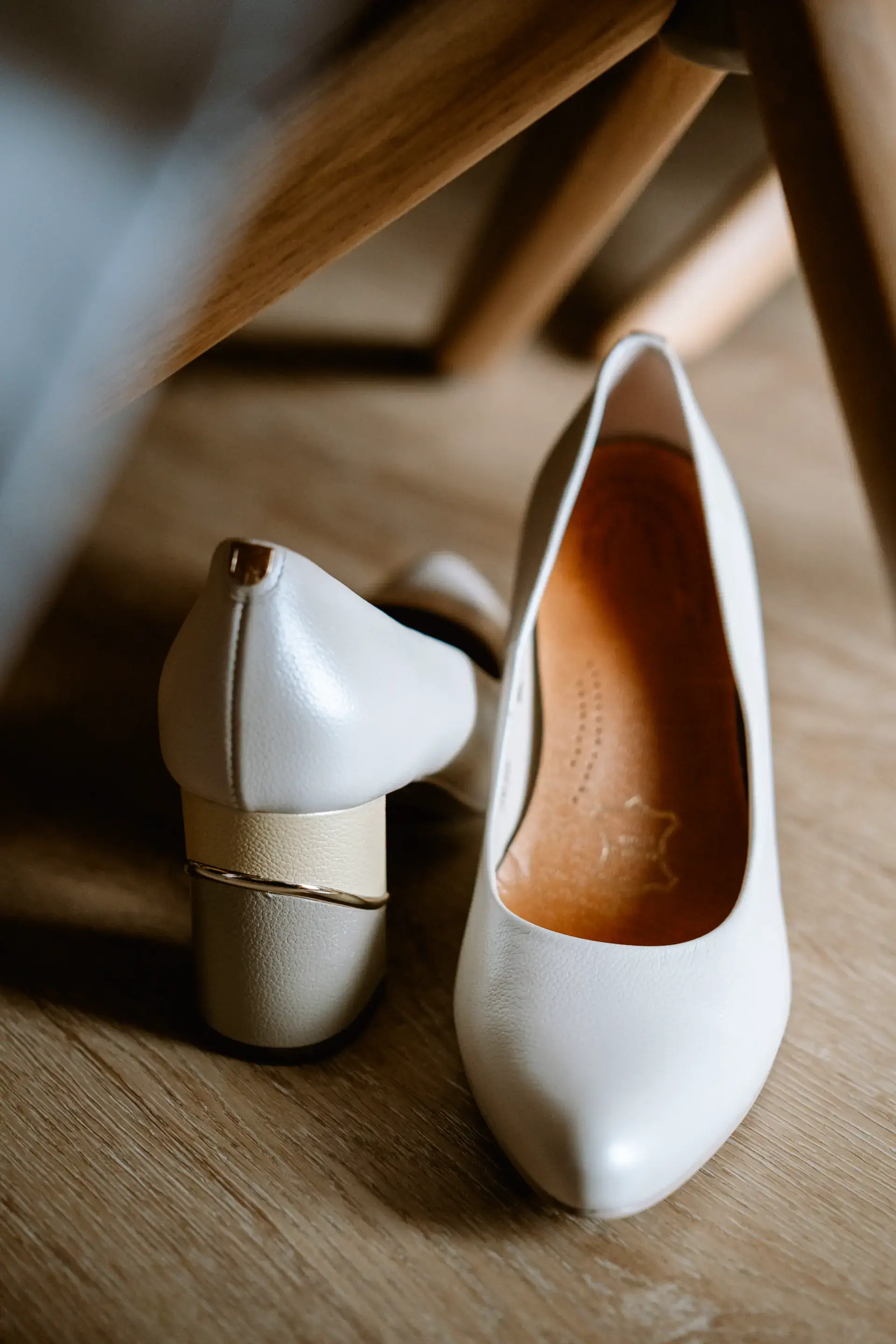 Los zapatos blancos de la novia sobre el suelo de madera, en Cáceres