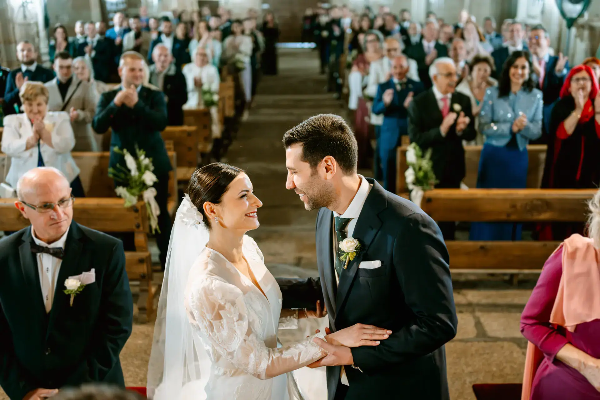 Los novios se miran en el altar mientras los invitados aplauden, en Cáceres