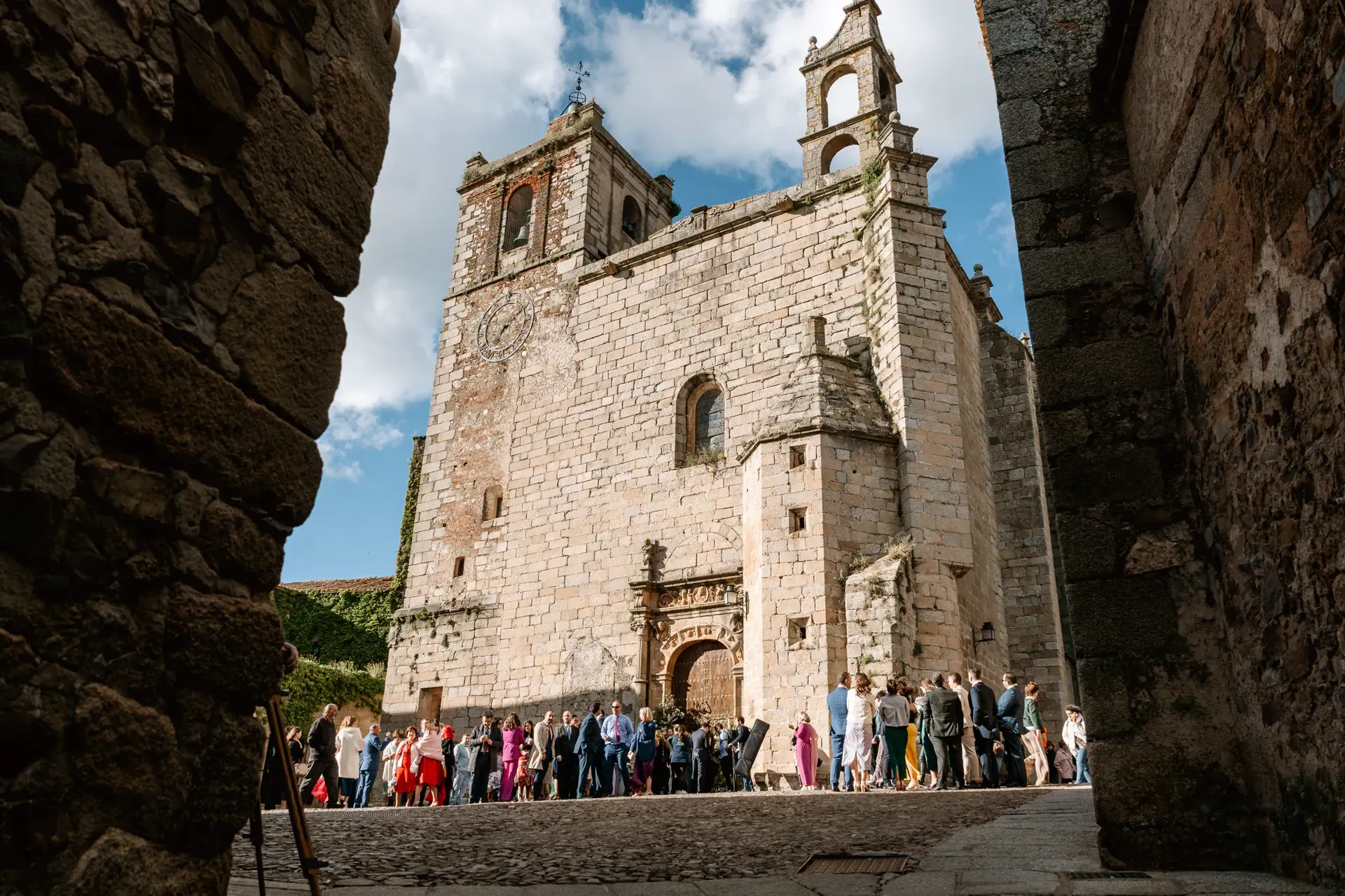 La iglesia de San Mateo vista desde un arco de piedra, con los invitados a la puerta