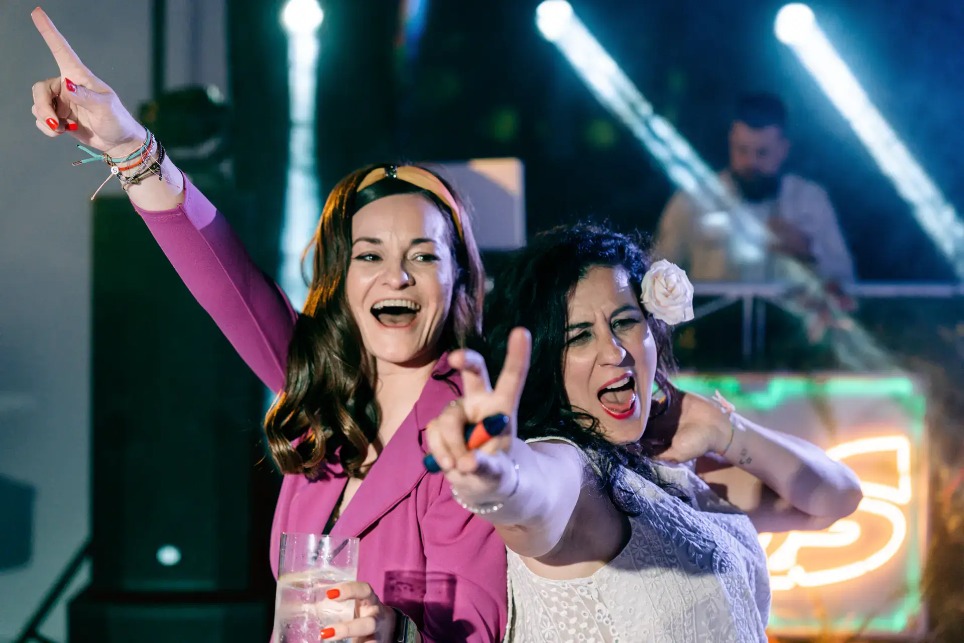 Dos invitadas cantan con el DJ en la fiesta, en Cáceres