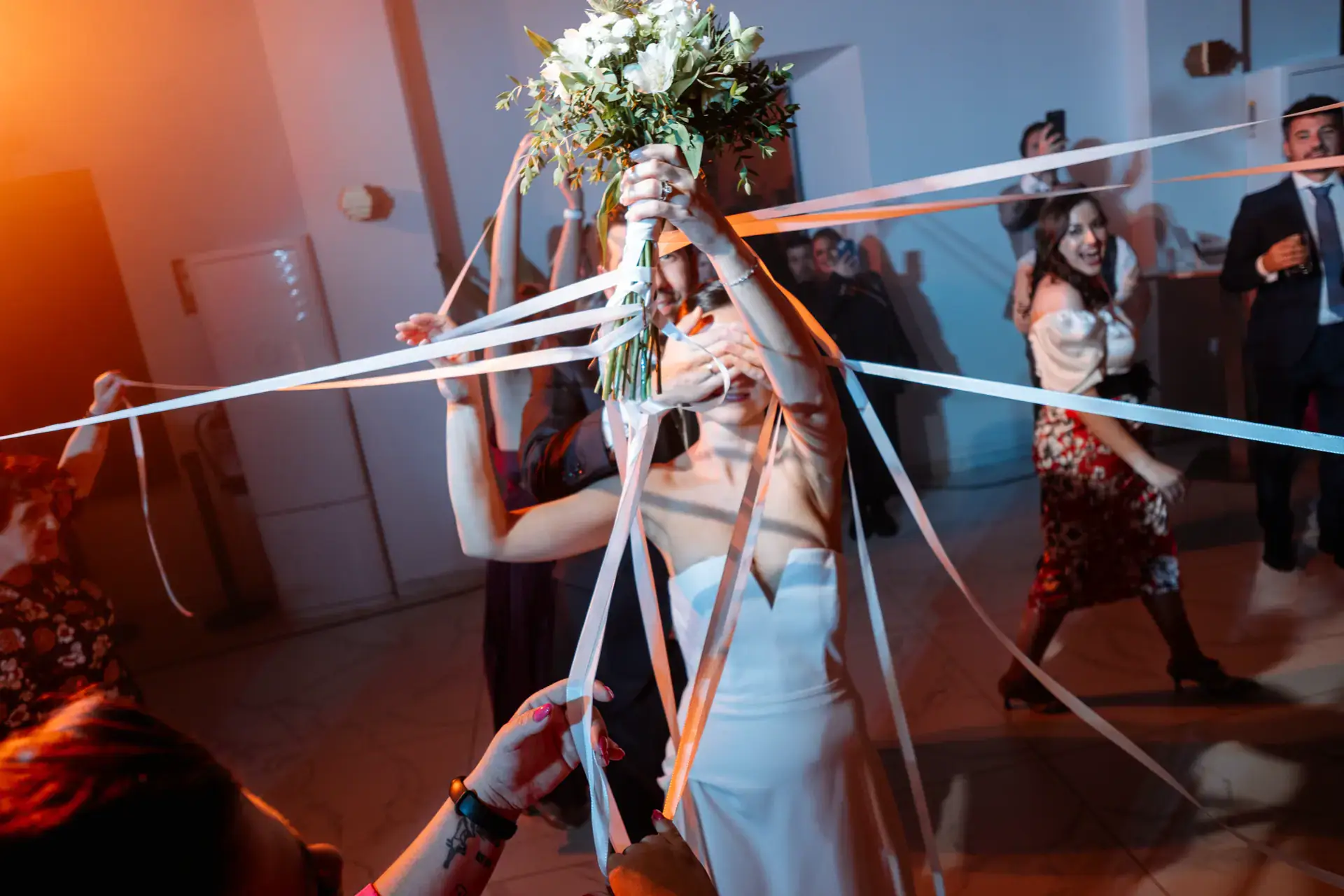 La novia con el ramo atado a cintas que sujetan los invitados, en Cáceres