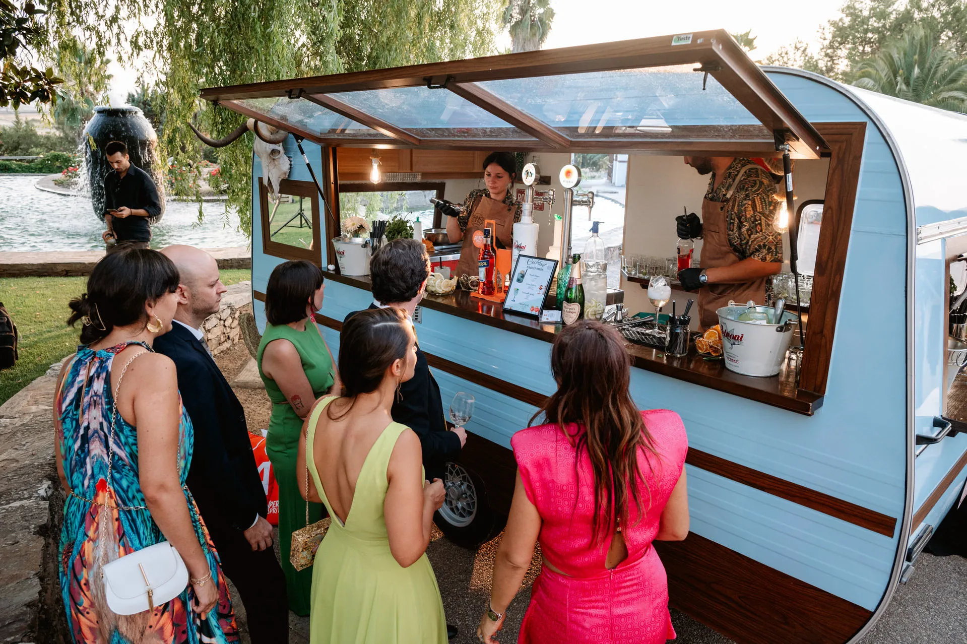 Invitadas piden bebidas en una caravana de cócteles