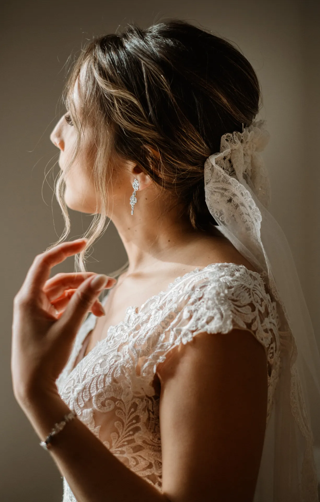 Novia de perfil con velo y vestido de encaje