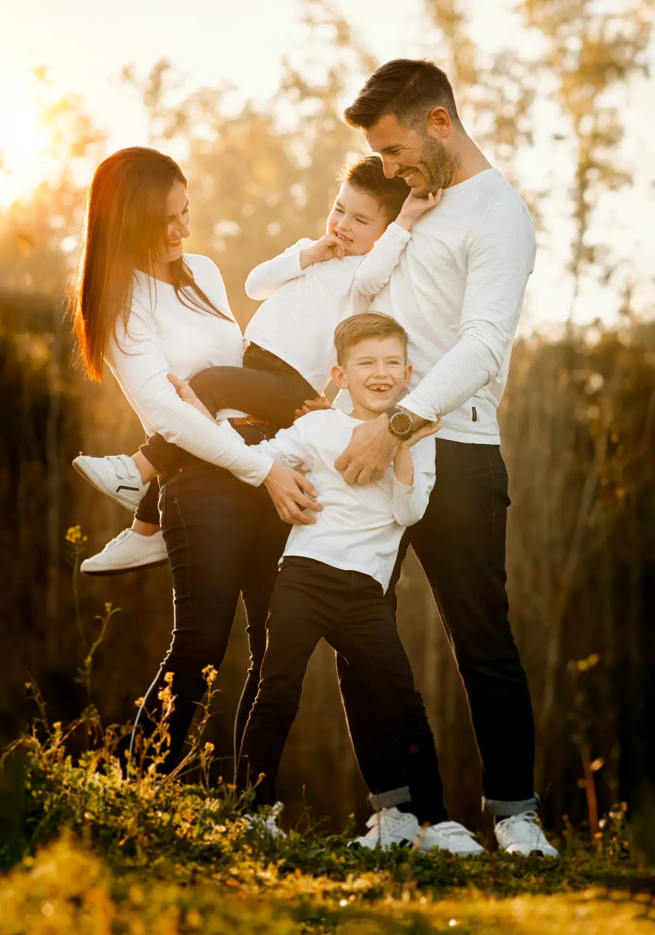 Familia abrazada al atardecer en el campo