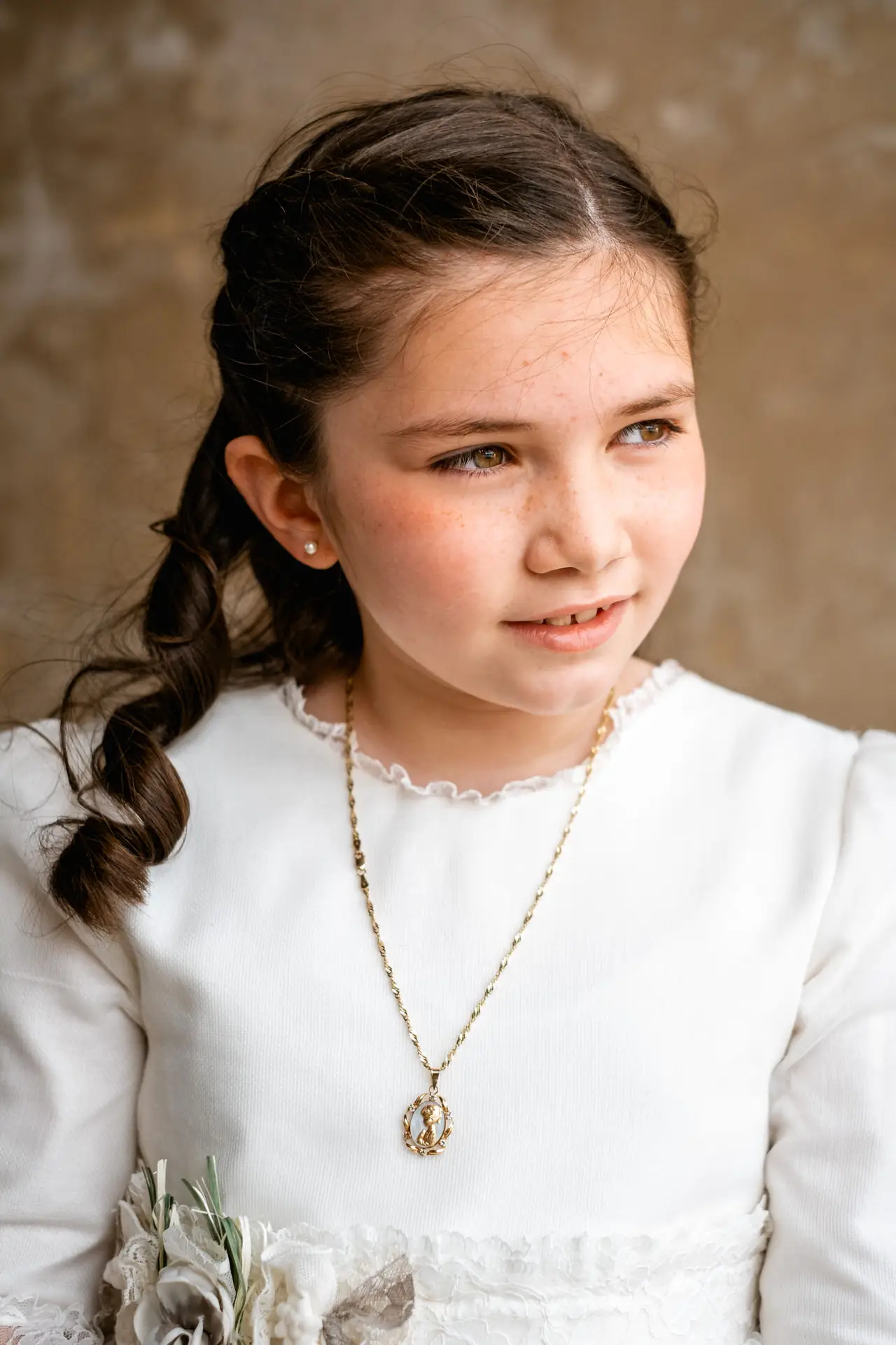 Retrato de niña con vestido blanco y medalla de comunión