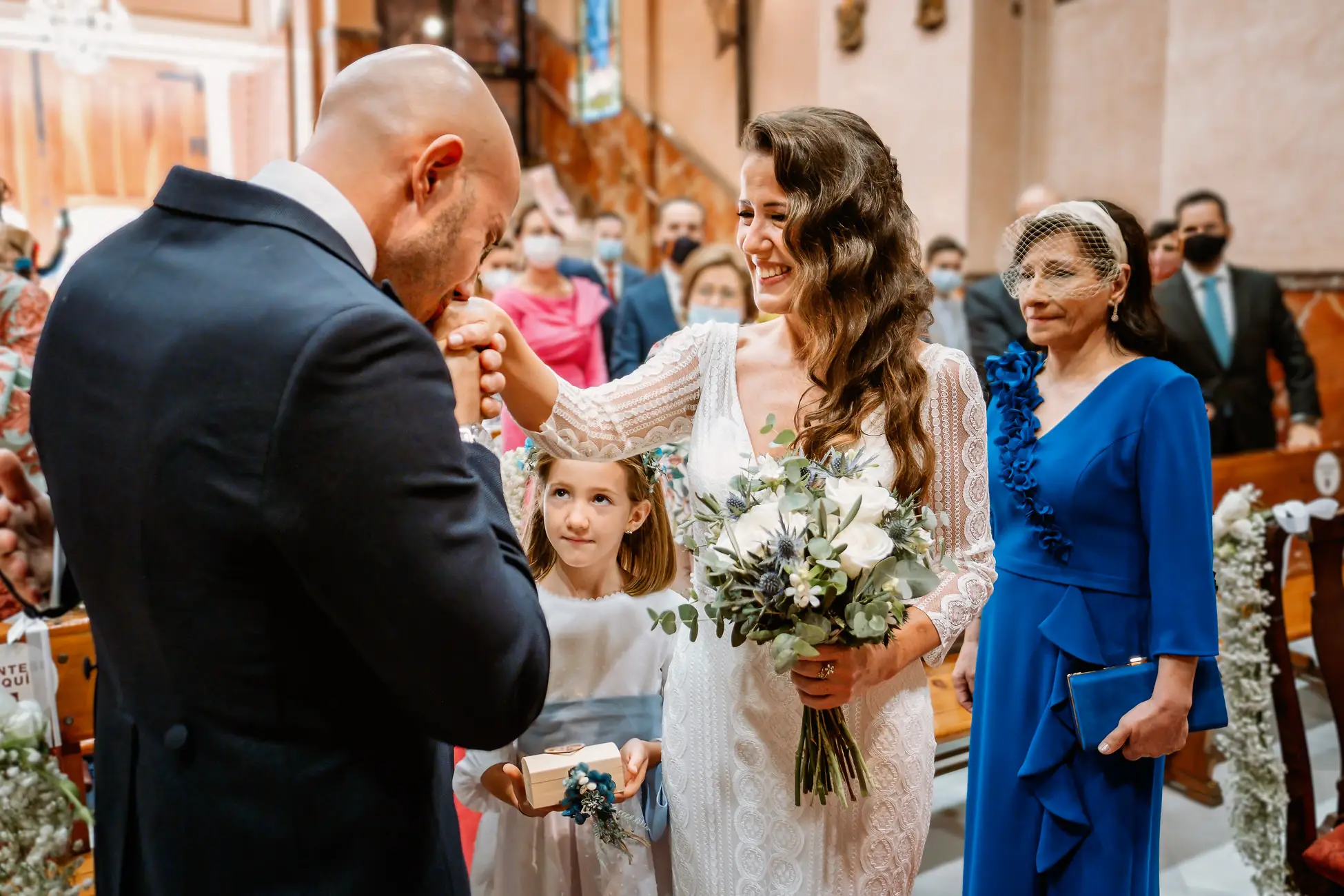 El novio besa la mano de la novia al llegar al altar