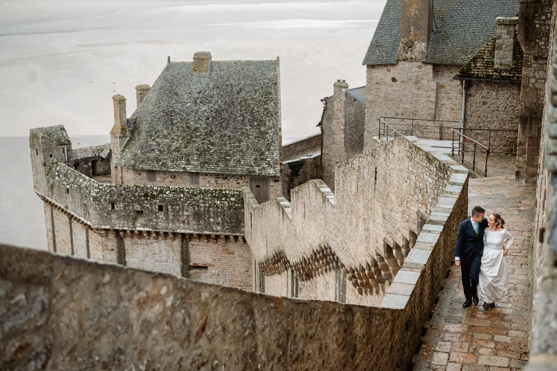 Los novios en la muralla del Mont Saint-Michel sobre los tejados