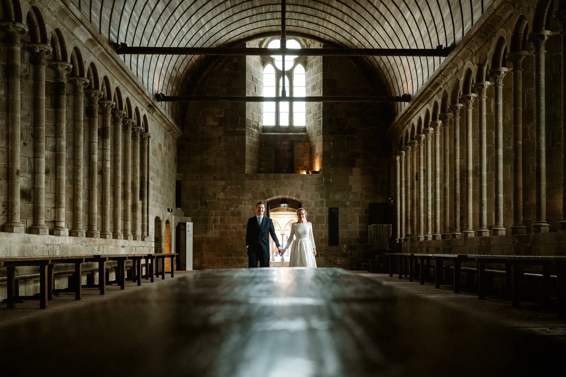 Los novios al fondo del refectorio de la abadía, en su postboda en Francia