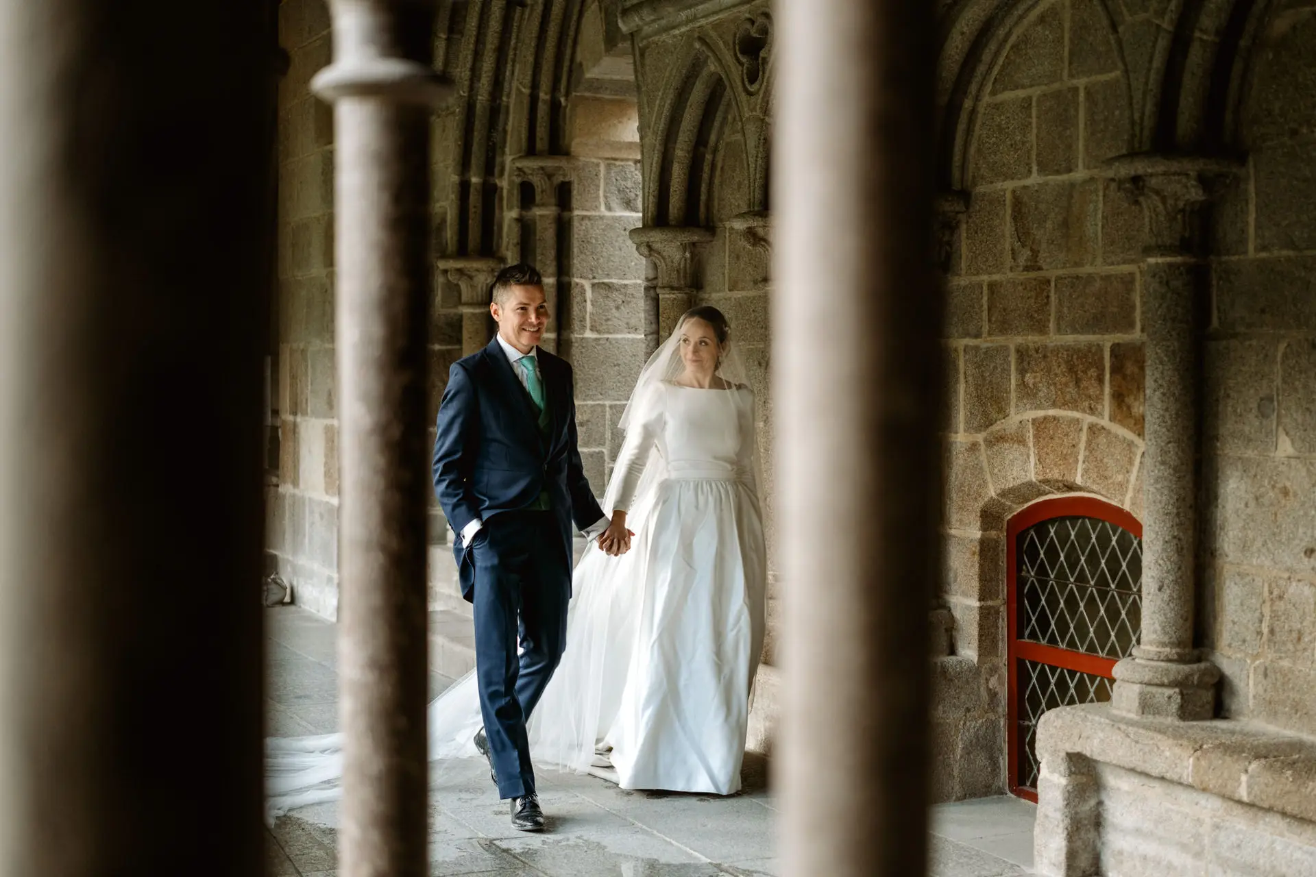 Los novios pasean entre las columnas del claustro, en su postboda en Francia