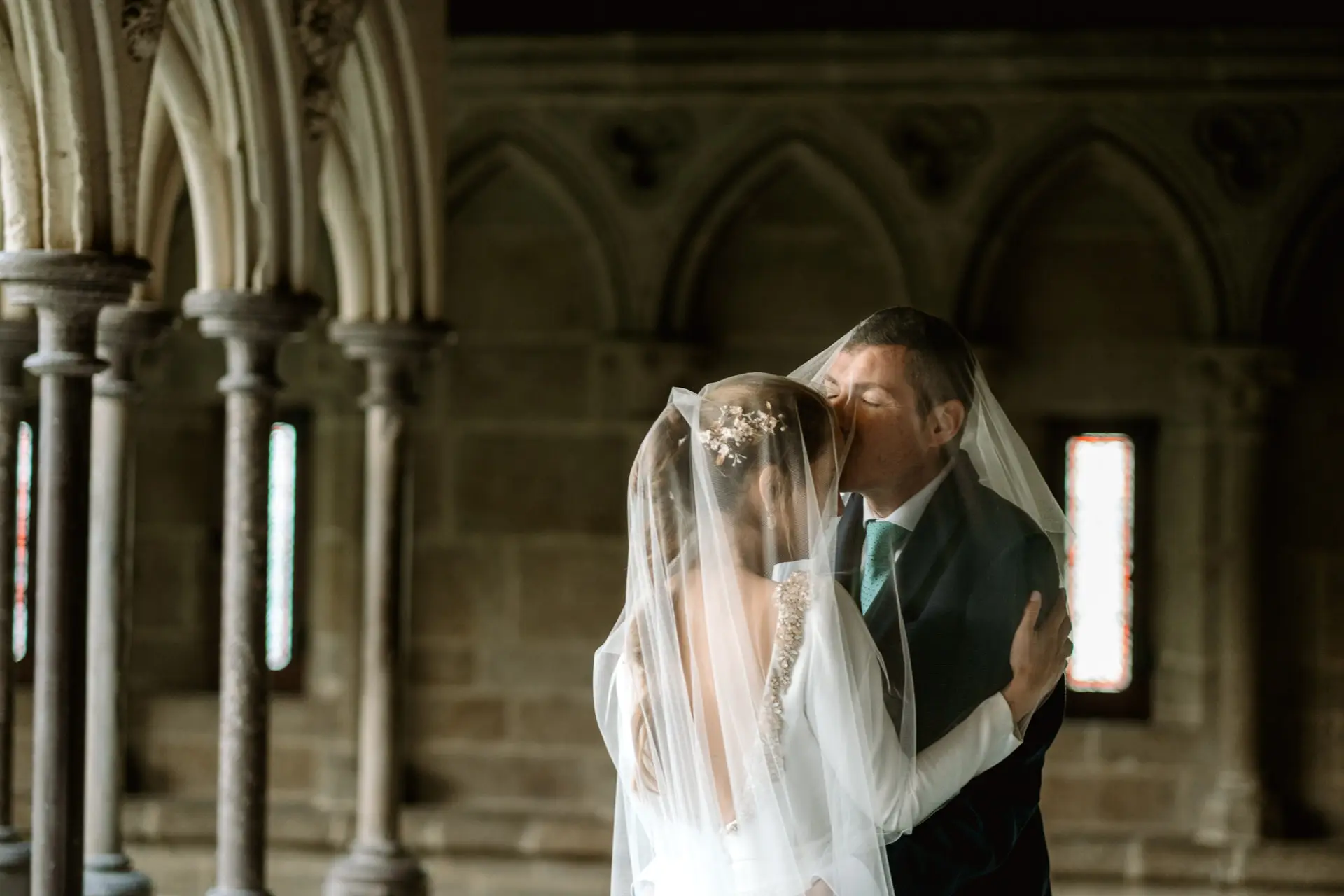Beso de los novios bajo el velo en el claustro, en su postboda en Francia