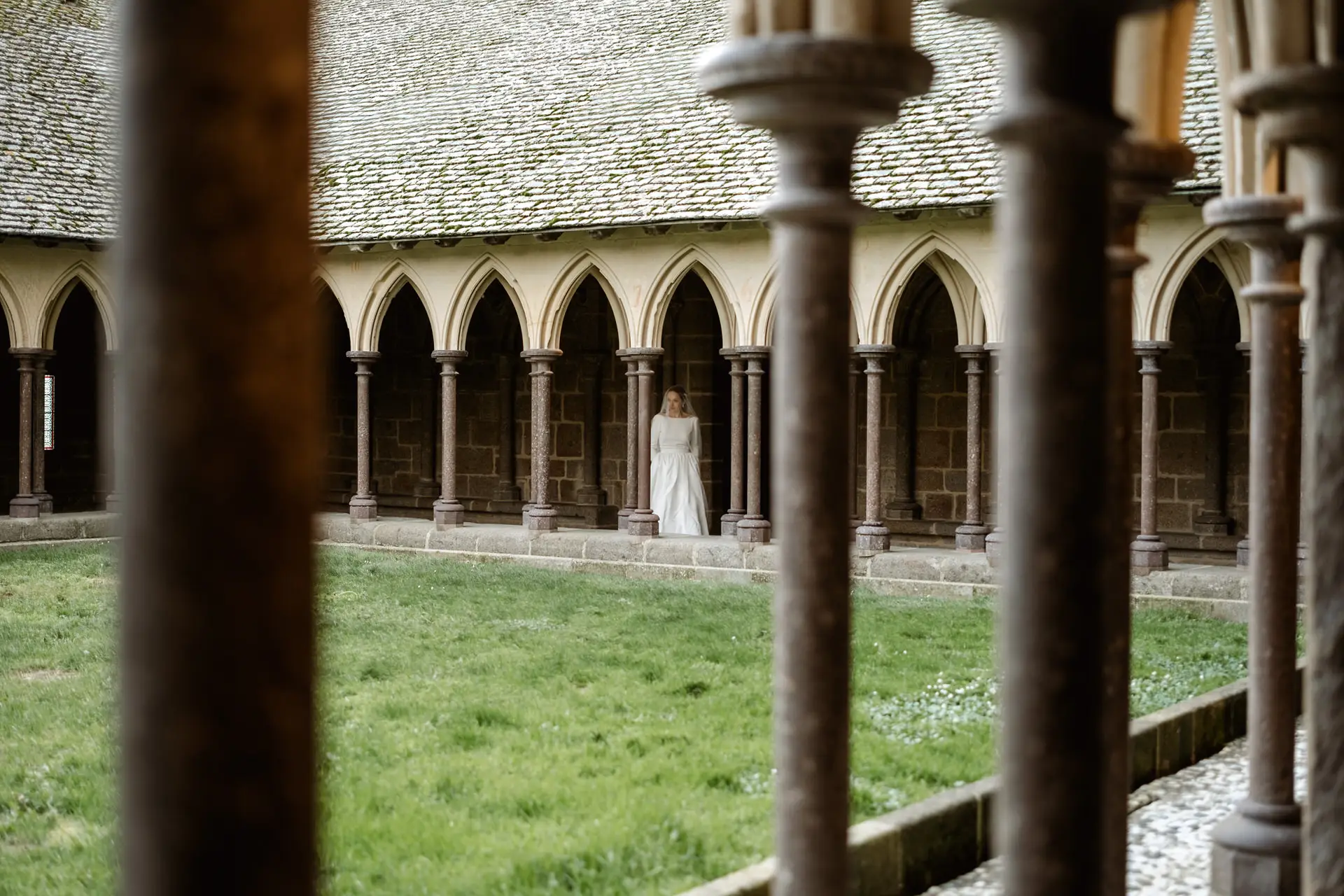 La novia vista entre las columnas del claustro, en su postboda en Francia