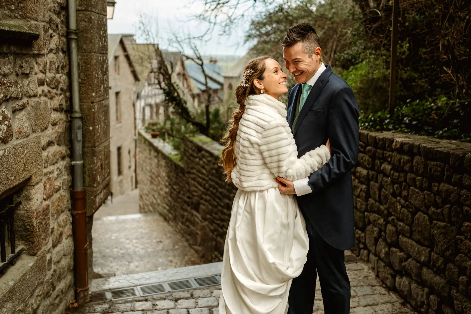 Los novios abrazados en una calle de piedra del Mont Saint-Michel