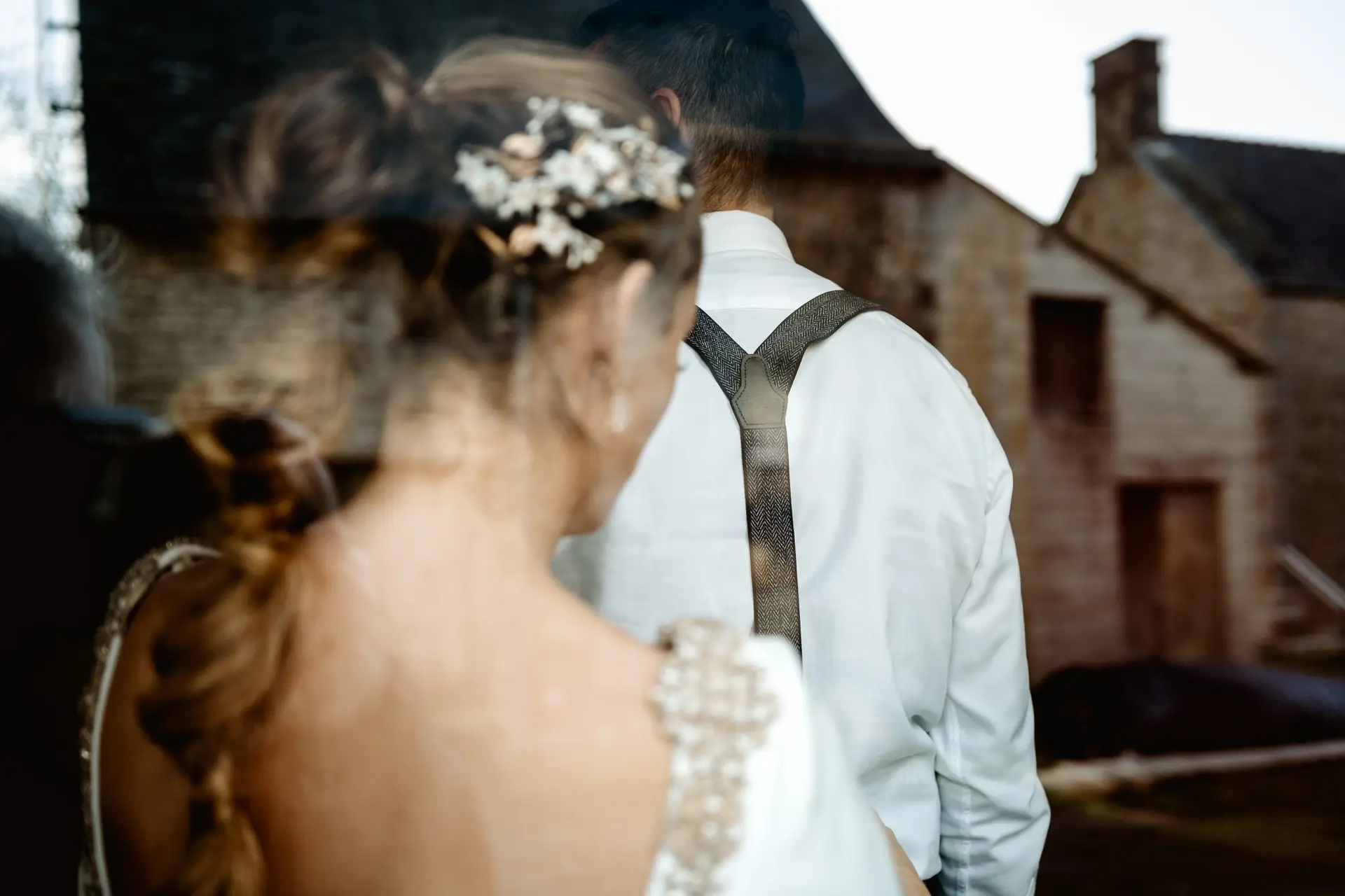 Detalle del tocado y la trenza de la novia junto al novio, en su postboda en Francia