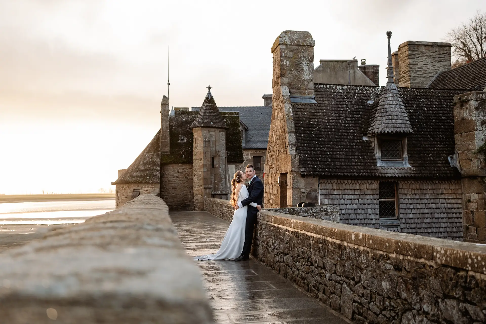 Los novios en la muralla del Mont Saint-Michel junto al mar