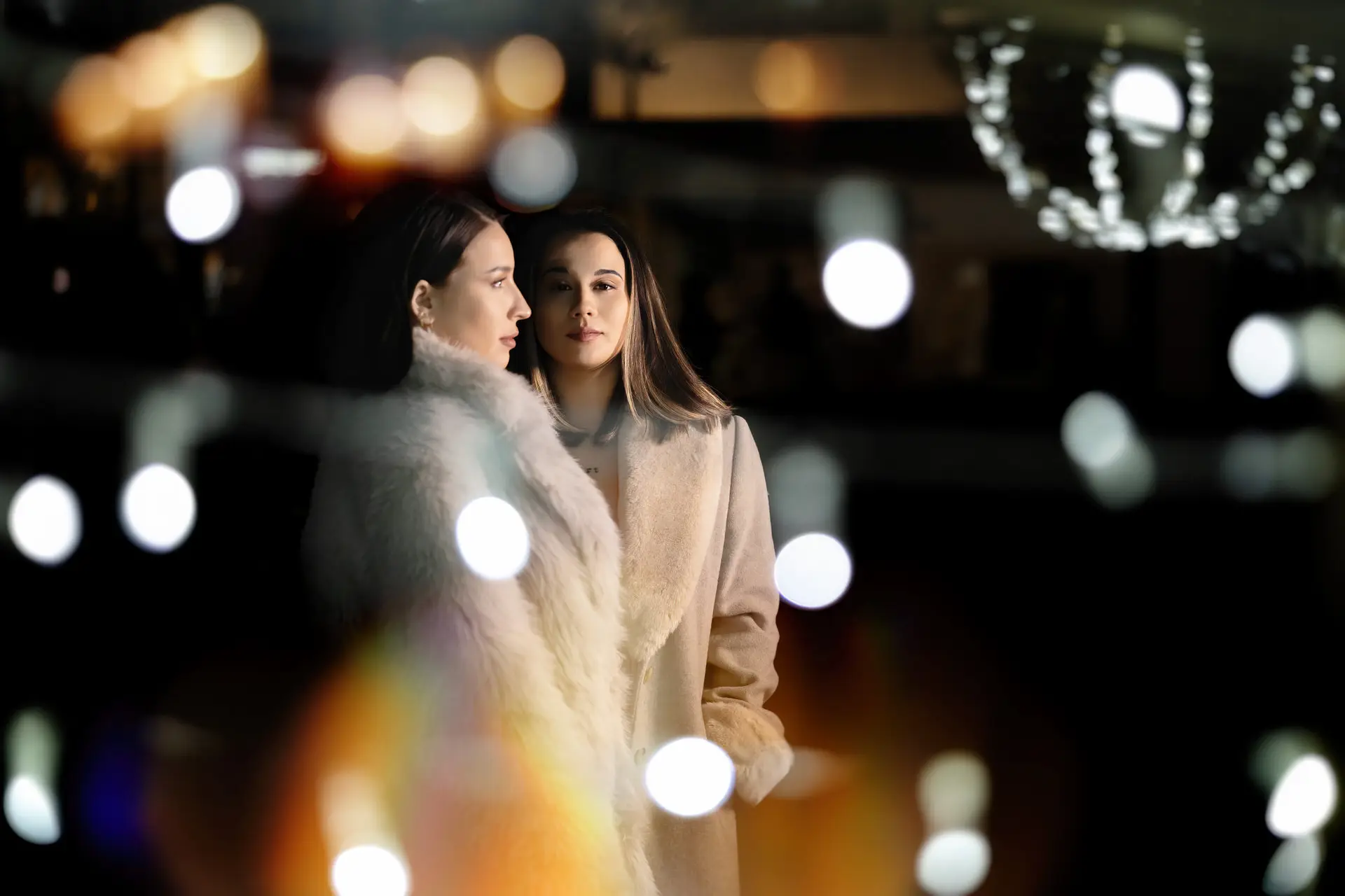 Rocío y Nines con abrigos de pelo entre luces navideñas, en Badajoz