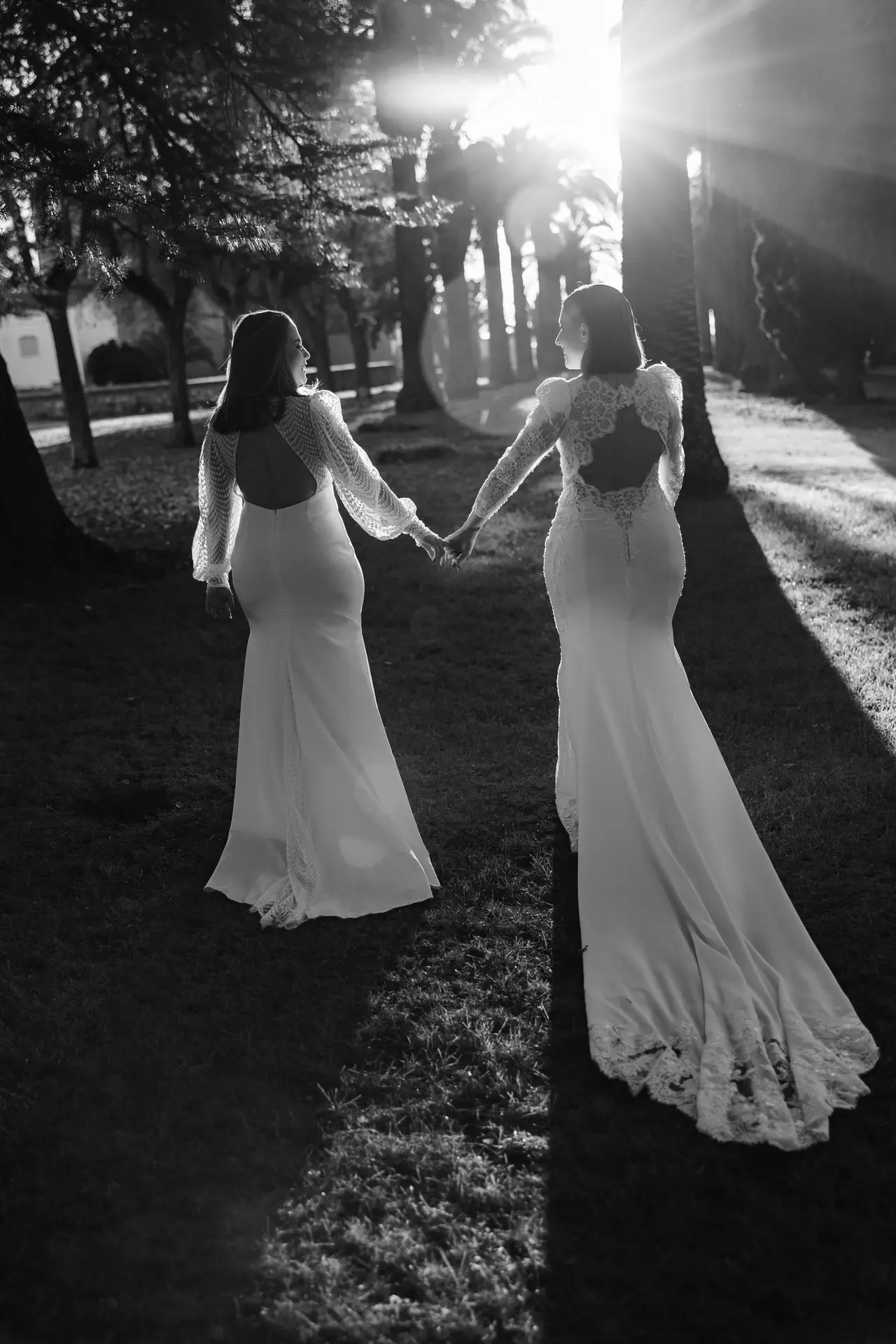Rocío y Nines caminan de la mano a contraluz, en blanco y negro, en Badajoz