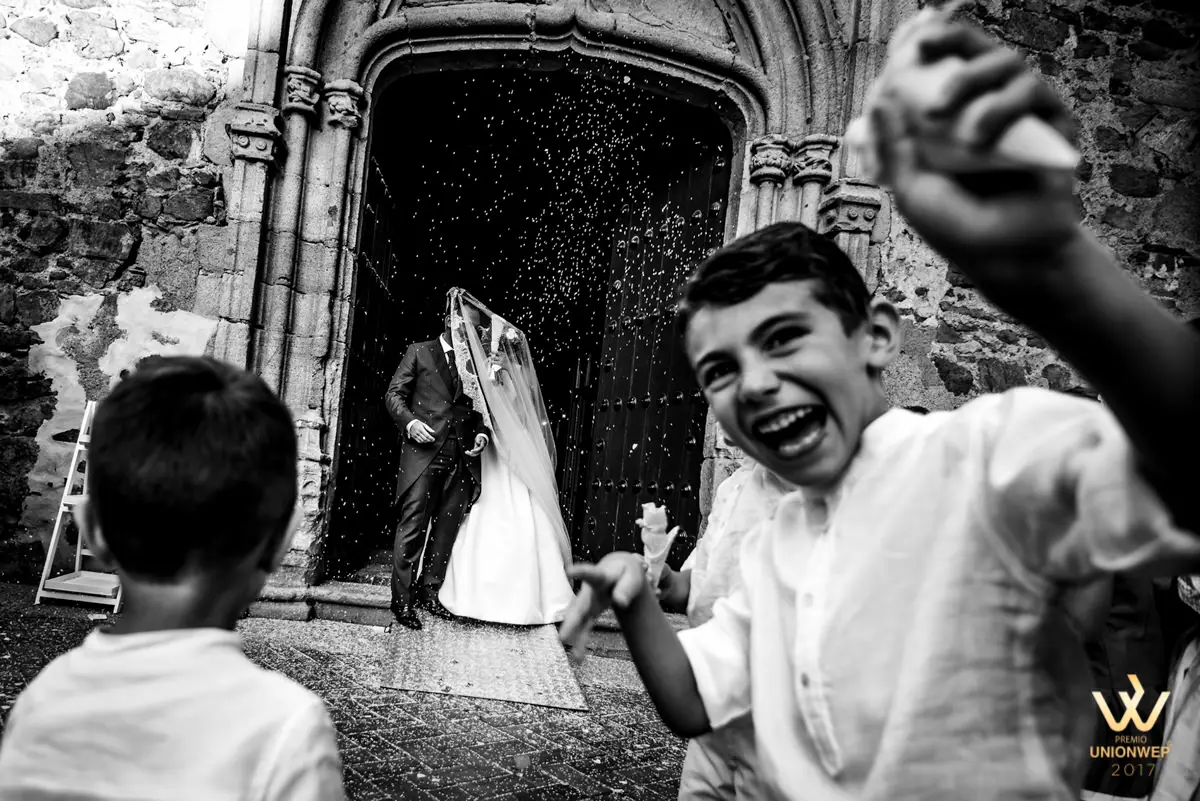 Foto premiada por Unionwep: un niño ríe a la salida de la iglesia junto a los novios