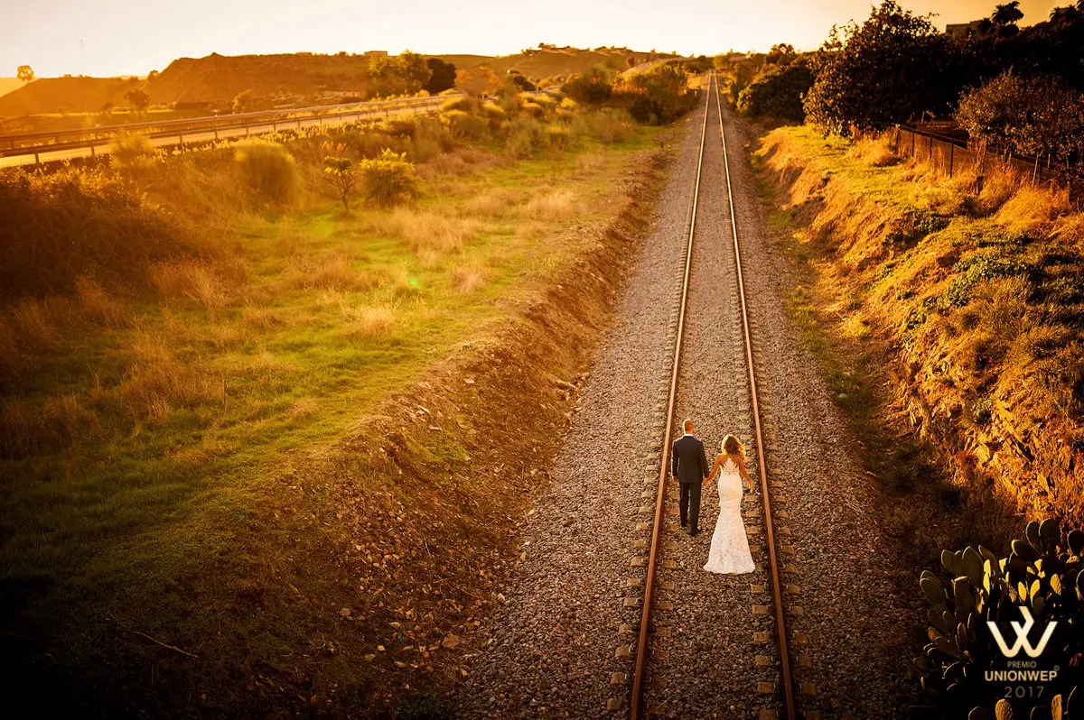 Foto premiada por Unionwep: los novios caminan por una vía de tren al atardecer